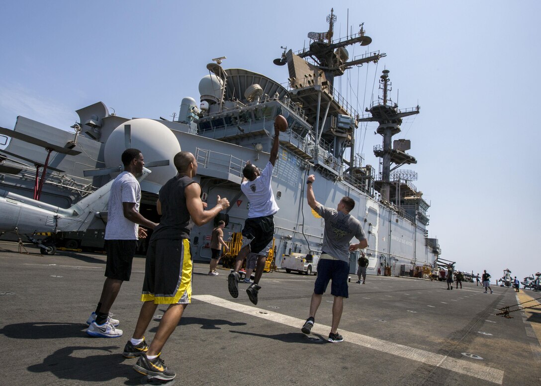 U.S. Marines and sailors assigned to 26th Marine Expeditionary Unit (MEU), play football on the flight deck of the USS Kearsarge (LHD 3) during a steel beach Morale Welfare and Recreation event, Sept. 20, 2013.The 26th MEU is a Marine Air-Ground Task Force forward-deployed to the U.S. 5th and 6th Fleet areas of responsibility aboard the Kearsarge Amphibious Ready Group serving as a sea-based, expeditionary crisis response force capable of conducting amphibious operations across the full range of military operations. (U.S. Marine Corps photo by Sgt. Christopher Q. Stone, 26th MEU Combat Camera/Released)