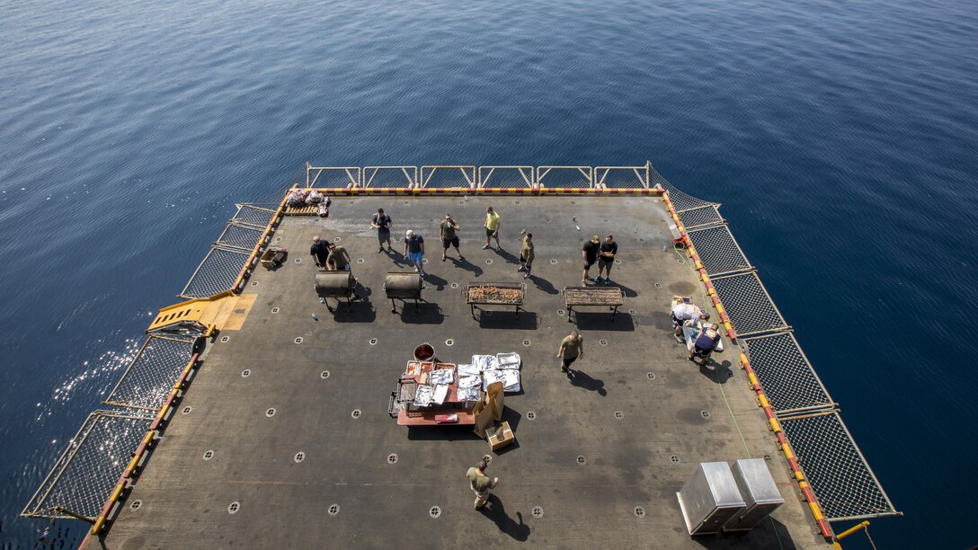 U.S. Marines and sailors assigned to 26th Marine Expeditionary Unit (MEU), grill food on an aircraft elevator of the USS Kearsarge (LHD 3) during a steel beach Morale Welfare and Recreation event, Sept. 20, 2013.The 26th MEU is a Marine Air-Ground Task Force forward-deployed to the U.S. 5th and 6th Fleet areas of responsibility aboard the Kearsarge Amphibious Ready Group serving as a sea-based, expeditionary crisis response force capable of conducting amphibious operations across the full range of military operations. (U.S. Marine Corps photo by Sgt. Christopher Q. Stone, 26th MEU Combat Camera/Released)