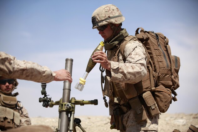 A mortarman with Fox Company, 2nd Battalion, 3rd Marine Regiment, prepares to load an 81 mm mortar tube to provide supporting fire for the infantry platoons taking out simulated enemy targets, Sept. 11, 2013, as part of the air assault course at Marine Corps Air Ground Combat Center Twentynine Palms, Calif. The AAC is part of the month-long Integrated Training Exercise. (U.S. Marine Corps photo by Cpl. Sarah Dietz)