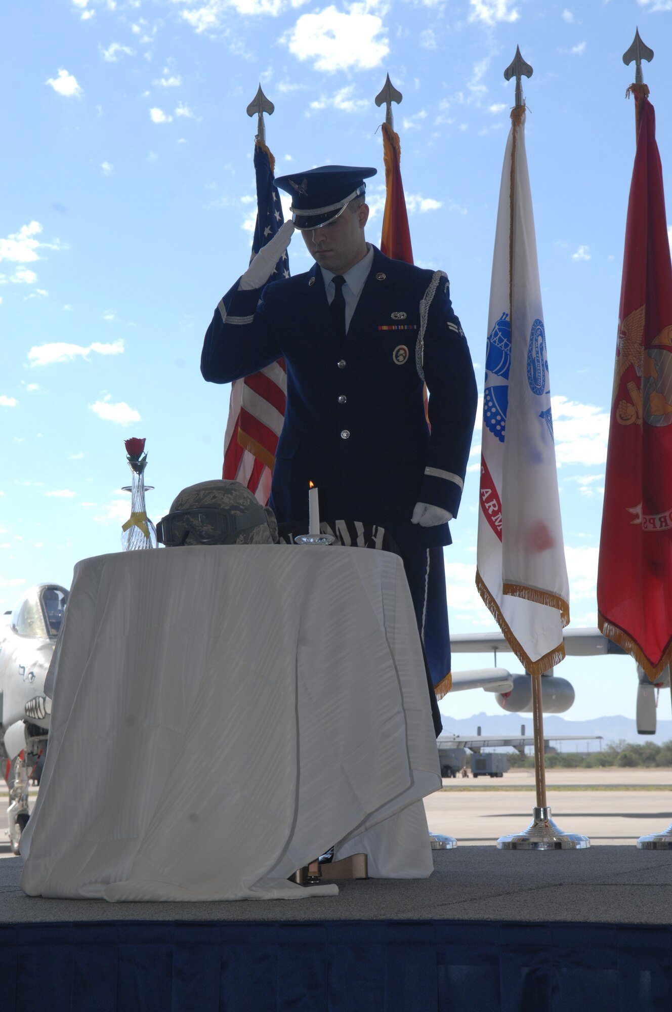Airman 1st Class Michael Letendre, 355th Force Support Squadron Honor Guardsman, salutes a table setting during the POW/MIA ceremony at Davis-Monthan Air Force Base, Ariz., Sept. 20, 2013. The table is set for one with specific characteristics to remember those lost or held captive during wartimes.
