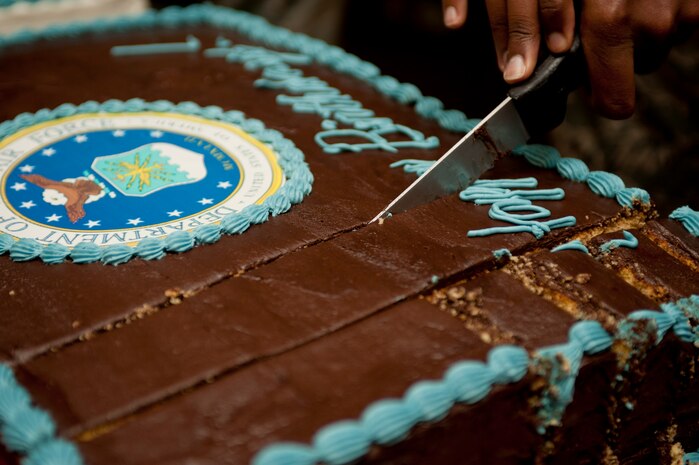 Airman 1st Class Timothy Tipton, 99th Communication Squadron wing information assurance officer, cuts an Air Force 66th birthday cake at the Crosswinds Dining Facility Sept. 18, 2013, at Nellis Air Force Base, Nev., during lunch. The Air Force mission is to fly fight and win in air, space and cyberspace. (U.S. Air Force photo by Staff Sgt. Michael Charles)