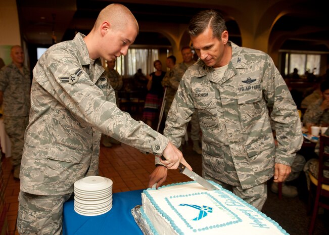Col. Barry Cornish, 99th Air Base Wing commander, and Airman 1st Class Morgan Roberts, 823rd Maintenance Squadron crew chief, cut an Air Force 66th birthday cake at the Crosswinds Dining Facility Sept. 18, 2013, at Nellis Air Force Base, Nev., during lunch. The Air Force was established in Sept. 18, 1947, as part of the National Security Act of 1947. (U.S. Air Force photo by Staff Sgt. Michael Charles)