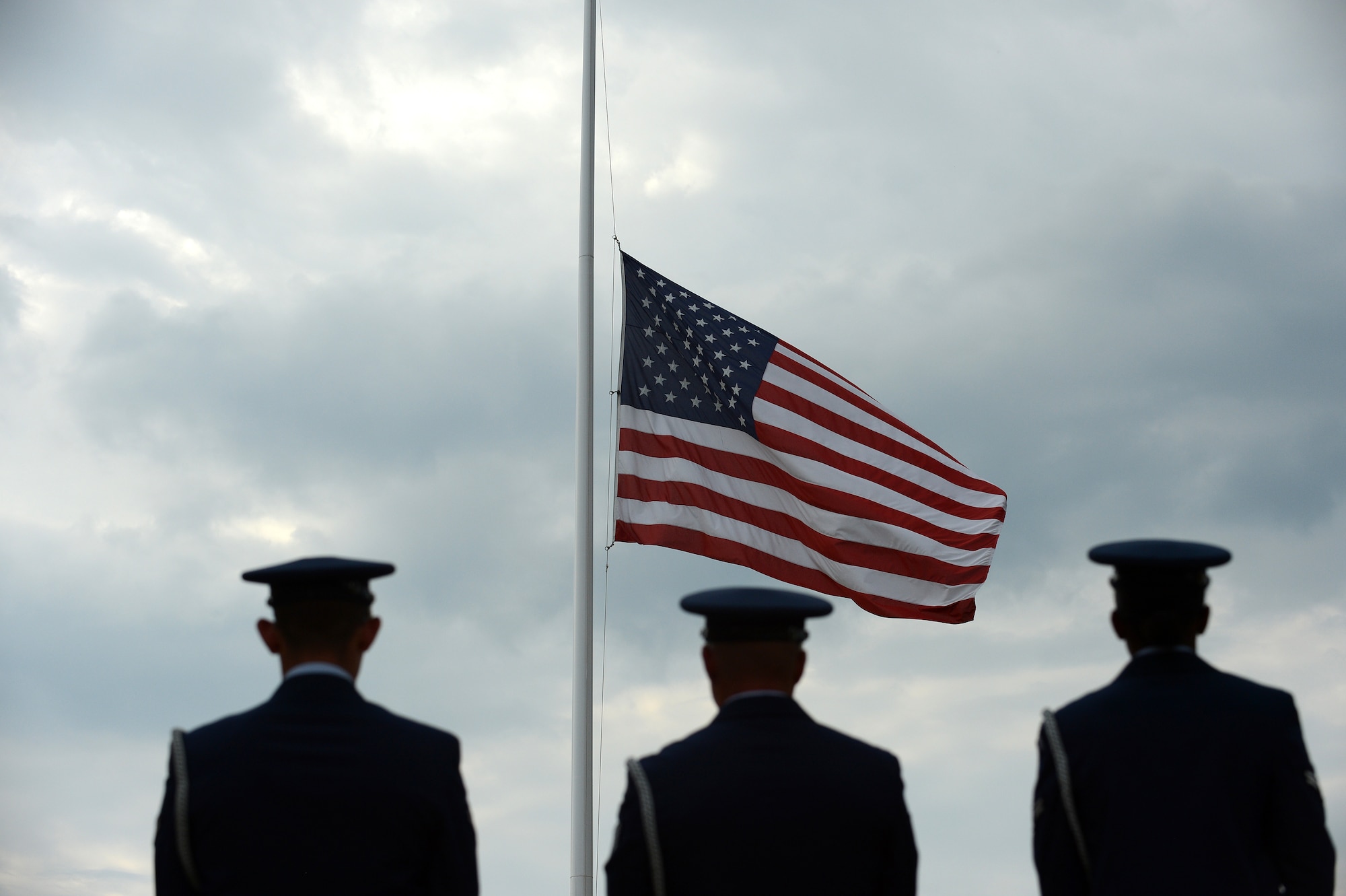 Members of the Team Shaw Honor Guard stand in wait before lowering the flag during a Prisoner of War and Missing in Action Remembrance Day ceremony at Shaw Air Force Base, S.C., Sept. 20, 2013. The ceremony included a World War II POW, as well as a 21-gun salute and a wreath-laying ceremony. (U.S. Air Force photo by Airman 1st Class Daniel Blackwell/Released)