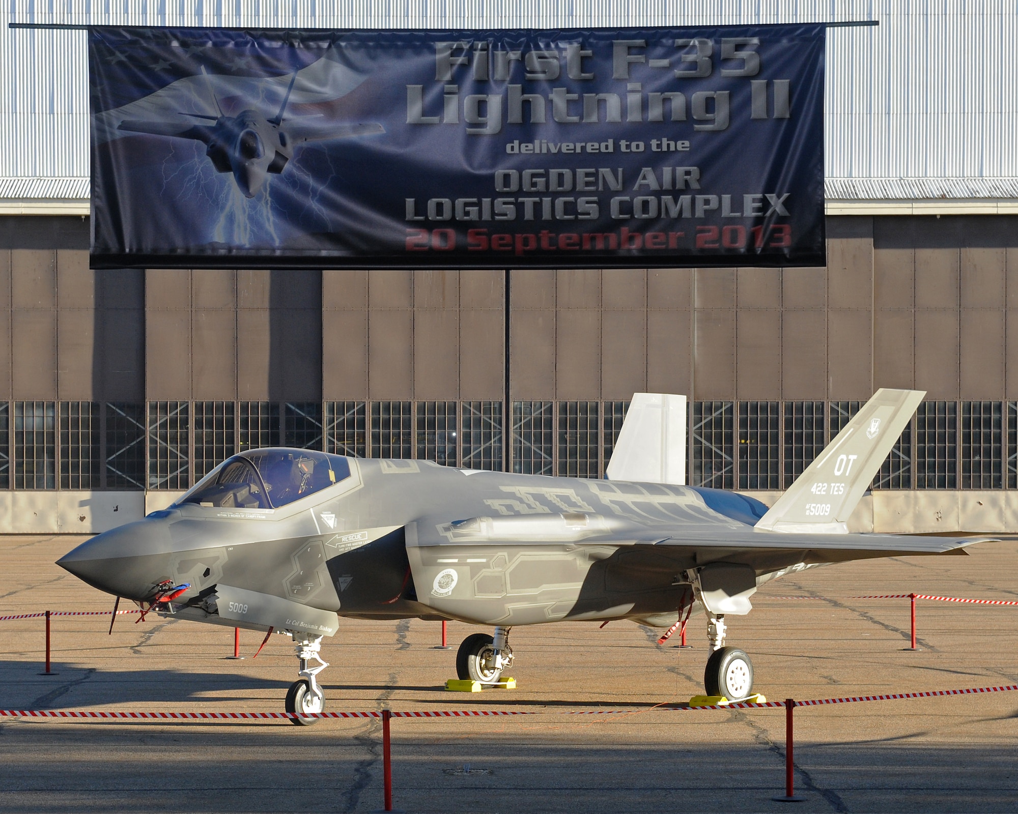 The first F-35A Lightning II Joint Strike Fighter to arrive at Hill Air Force Base, Utah, sits on display in front of a hangar the morning of Sept. 20, 2013. Hill, Lockheed Martin, Utah elected officials and the community gathered for a ceremony to commemorate the beginning of F-35 depot maintenance at Hill AFB. The F-35 is a multi-variant, multi-role, fifth generation fighter, and will undergo organic depot modification work at Hill AFB. (U.S. Air Force photo by Alex R. Lloyd/Released)