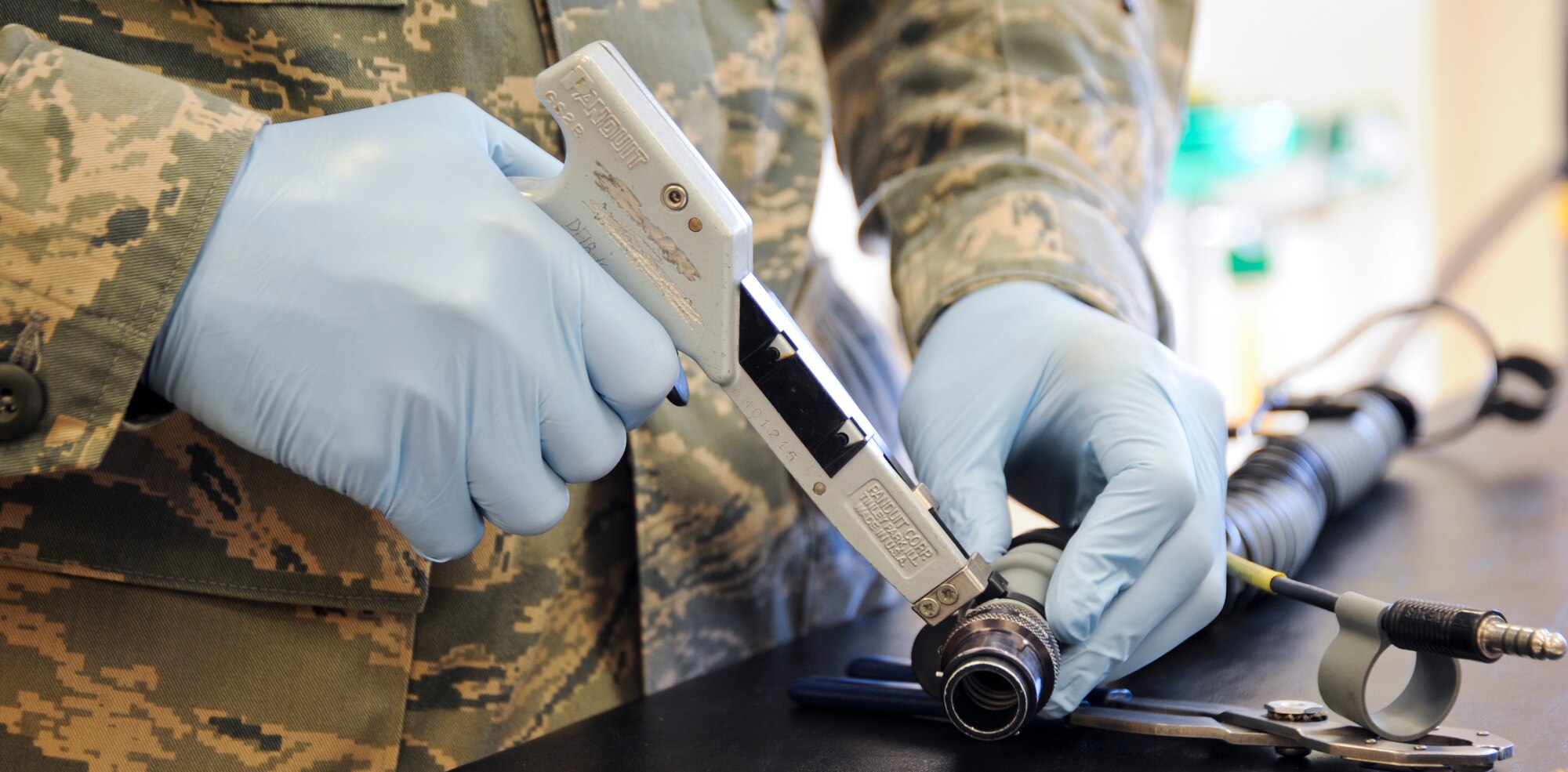 U.S. Air Force Airman 1st Class Jose Padilla, 358th Fighter Squadron aircrew flight equipment apprentice, tightens an oxygen tube with a zip tie at Davis-Monthan Air Force Base, Ariz., Sept. 19, 2013. Tightening the tube is a safety precaution to ensure the oxygen flows through the tube correctly without leaks. (U.S. Air Force photo by Airman 1st Class Justin Veazie/Released)