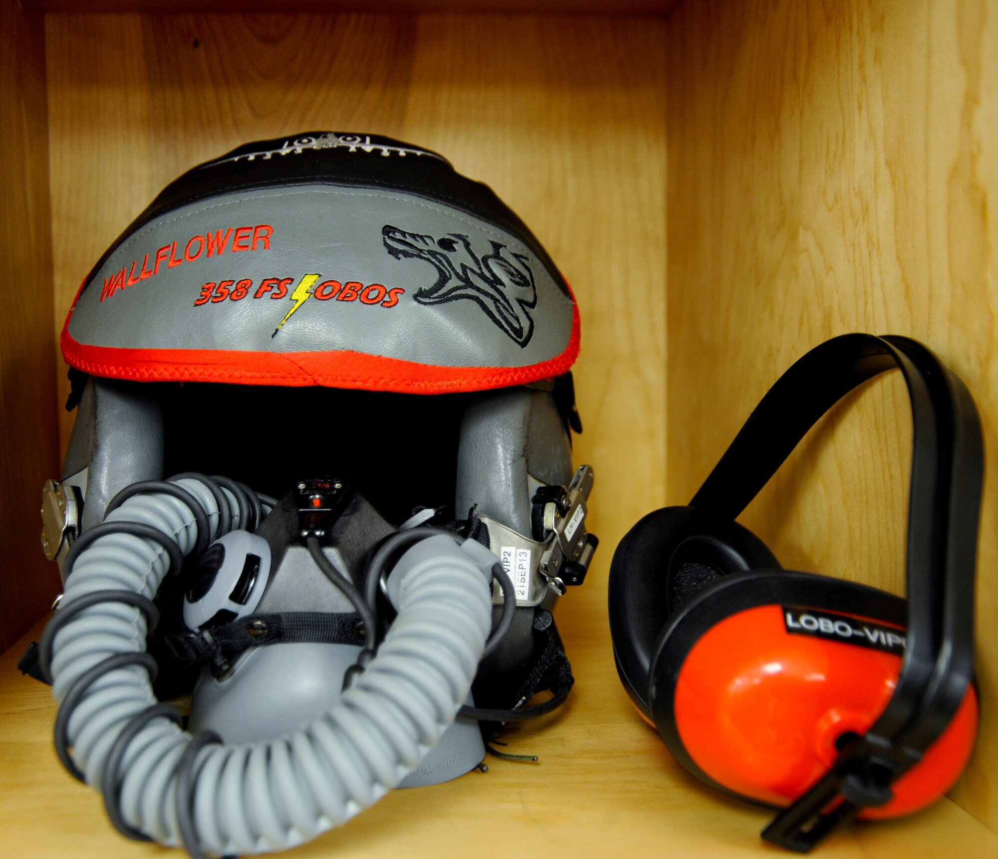 A flight helmet sits on a shelf after being inspected at Davis-Monthan Air Force Base, Ariz., Sept. 19, 2013. A flight helmet provides impact protection for pilots to reduce the risk of head injury and protection from wind blast, and a visor to shield the eyes from sunlight, flash and laser beams. (U.S. Air Force photo by Airman 1st Class Justin Veazie/Released)