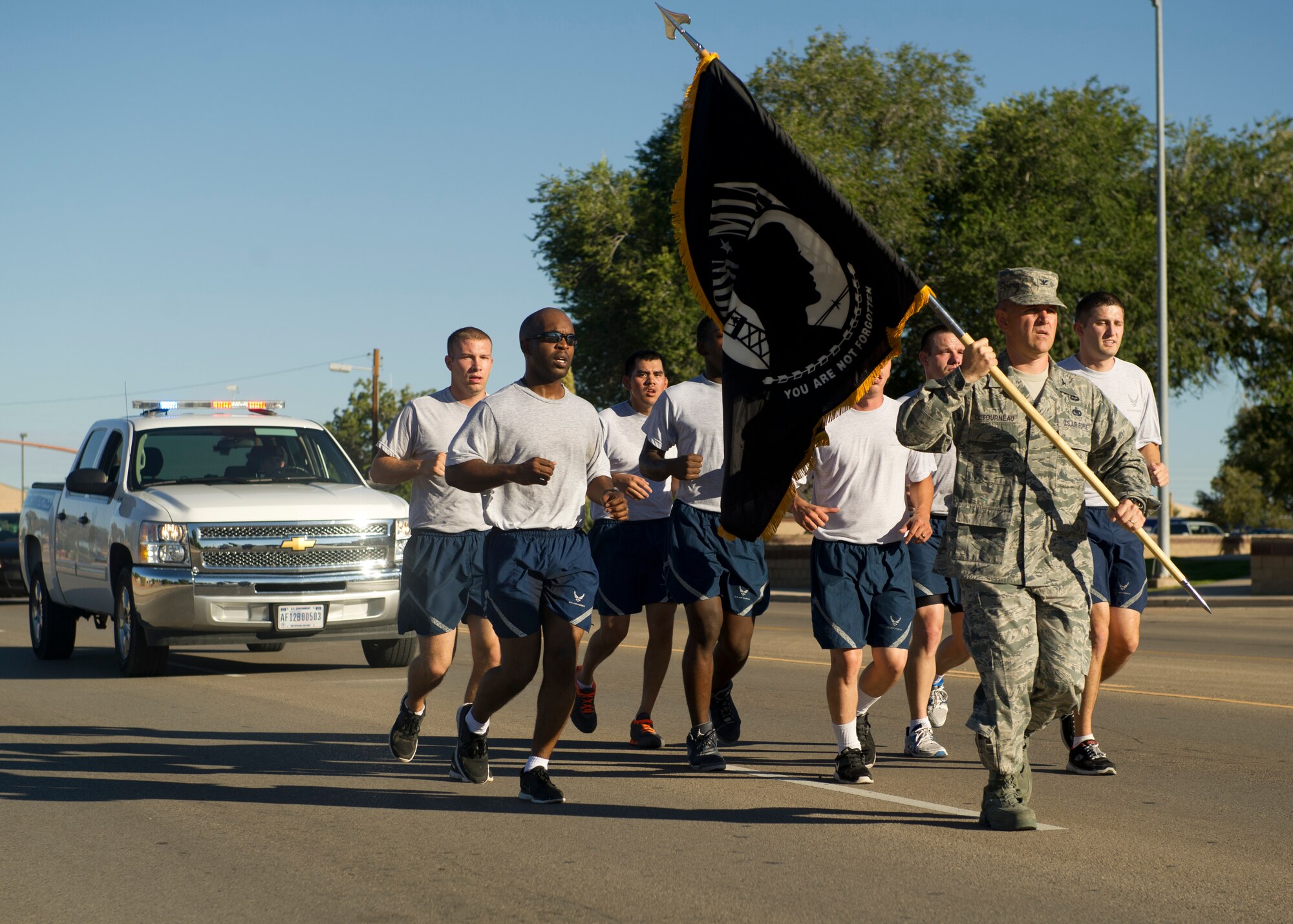 Colonel Robert Letourneau, 49th Material Maintenance Group commander, returns the POW/MIA flag after it has been carried for 24 hours in honor of POW/MIA Day of Remembrance at Holloman Air Force Base, N.M., Sept. 20. Members of Team Holloman paid their respects by taking shifts with the flag, running a total of 24 hours and always keeping the flag moving in honor of prisoners of war and service members missing in action. (U.S. Air Force photo by Airman 1st Class Chase Cannon/Released)