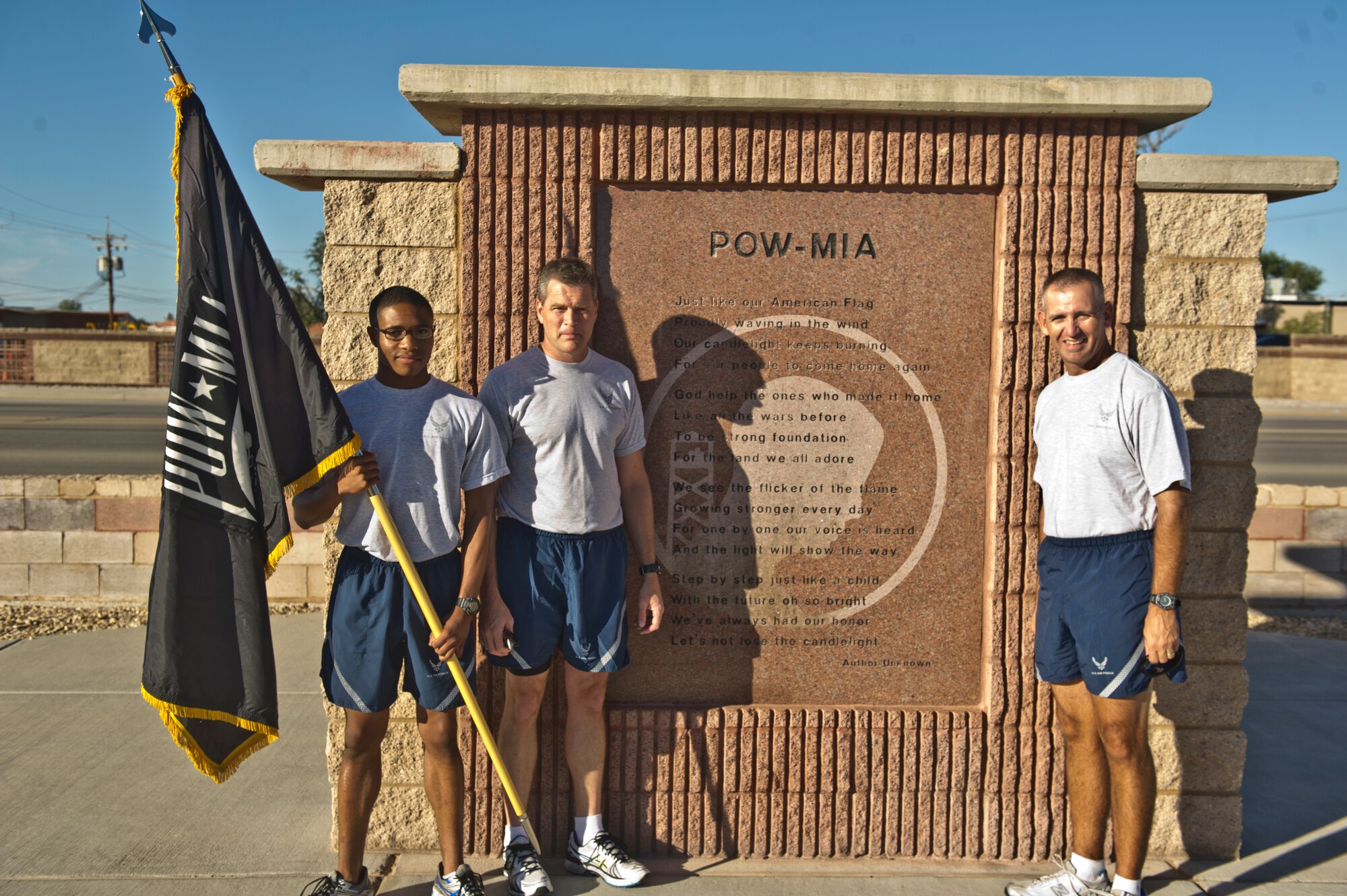 Colonel James Thompson, 49th Wing vice commander, 49th Wing Command Chief Master Sgt. James Patrie, and Airman 1st Class Michael Redford, 49th Wing Financial Analysis Technician, stand in front of the Holloman Air Force Base, N.M., POW/MIA memorial before beginning a run in honor of the POW/MIA Day of Remembrance at Sept. 19. Members of Team Holloman paid their respects by taking shifts with the flag, running a total of 24 hours and always keeping the flag moving in honor of prisoners of war and service members missing in action. (U.S. Air Force photo by Airman 1st Class Chase Cannon/Released)