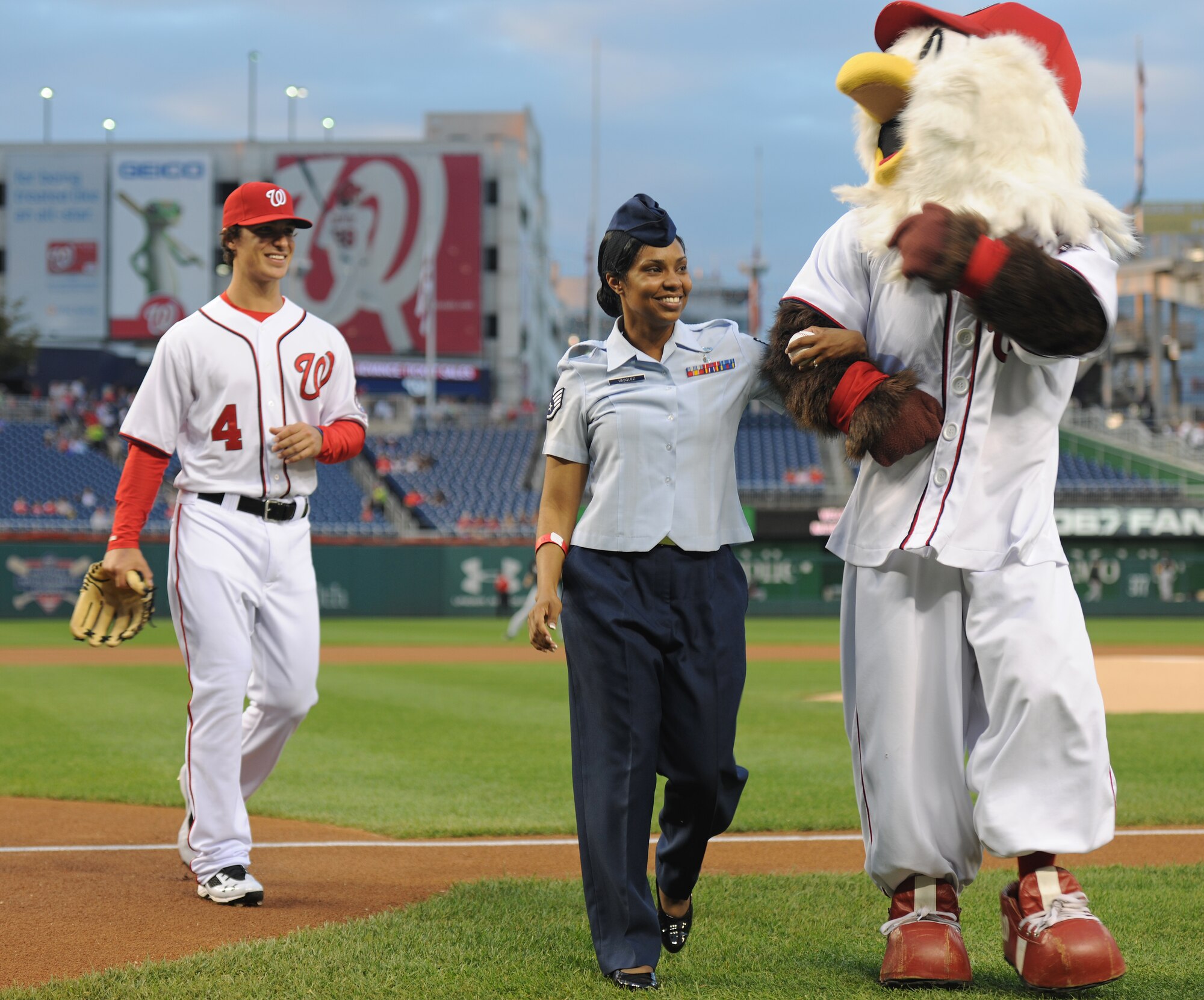 Washington Nationals mascot, Screech, escorts Staff Sgt. Capri Vazquez off the field during Air Force Night at Nationals Park, Washington, D.C., Sept. 19, 2013. Vazquez was selected among hundreds of other Airmen from the National Capital Region to make the Ceremonial First Pitch. Vazquez is an 11th Wing, Command Post senior controller. (U.S. Air Force photo/Airman 1st Class Erin O’Shea)  
