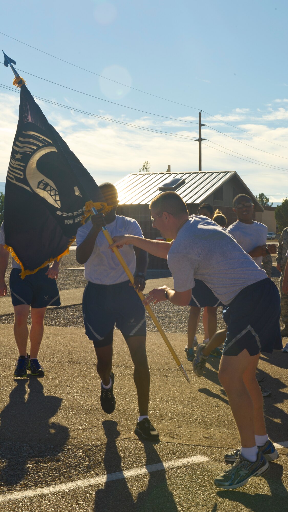Captain Stephen McQuillian, 49th Wing chief of civil law, receives the flag to begin the Wing Staff Agencies running shift during the POW/MIA Day of Remembrance at Holloman Air Force Base, N.M., Sept. 19. Members of Team Holloman paid their respects by taking shifts with the flag, running a total of 24 hours and always keeping the flag moving in honor of prisoners of war and service members missing in action. (U.S. Air Force photo by Airman 1st Class Leah Murray/Released)