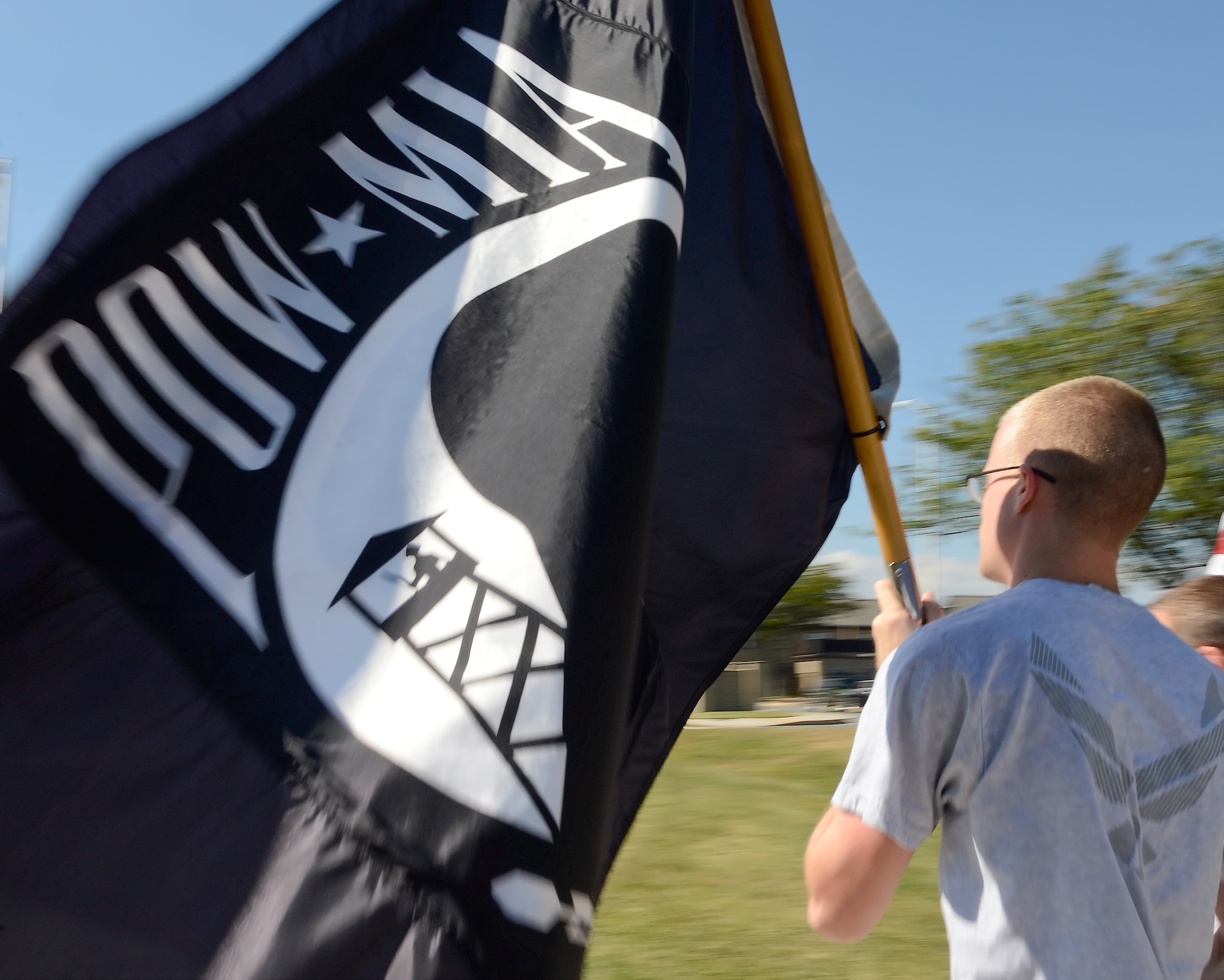 A member of Team Dover carries the prisoner of war/missing in action flag during a 24-hour vigil from 18-19 Sept. 2013 at Dover Air Force Base, Del. The runners ran a course which surrounded the heart of the base; the 436th Airlift Wing and the 512th Airlift Wing (Air Force Reserve Command) headquarters' buildings. (U.S. Air Force photo/Greg L. Davis)