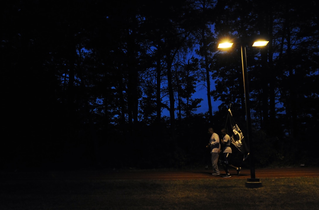Members of the POW/MIA Vigil Run carry the flag on Joint Base Andrews, Md., Sept. 19, 2013. The flag was to remain constantly in motion during the 24 hour vigil run. National POW/MIA Remembrance Day is observed across the nation on the third Friday of September each year in honor of those who were prisoners of war and those who are still missing in action.  (U.S. Air Force photo/Airman 1st Class Nesha Humes)