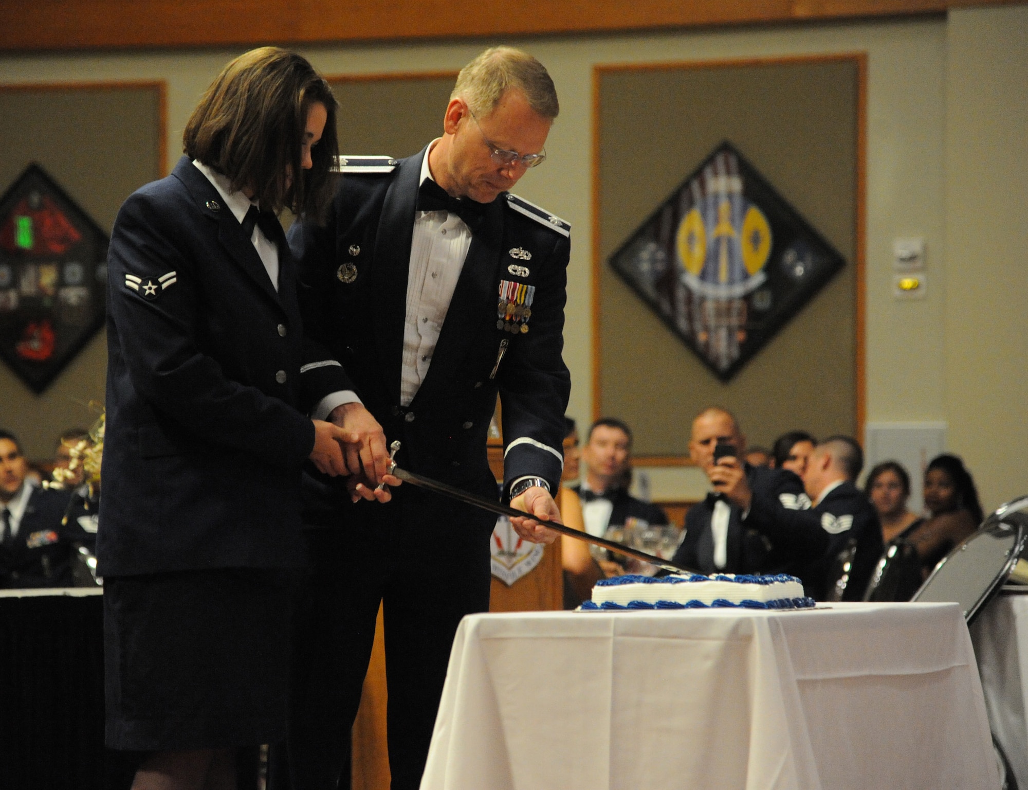 Airman 1st Class Courtney Tyson, 341st Medical Support Squadron medical administrative technician, and Lt. Col. Keith Hepler, 341st Maintenance Group deputy group commander, cut the ceremonial cake together at the Air Force Ball on Sept 14. The Grizzly Bend had a full house with more than 300 guests in attendance. (U.S. Air Force photo/Airman 1st Class Collin Schmidt) 