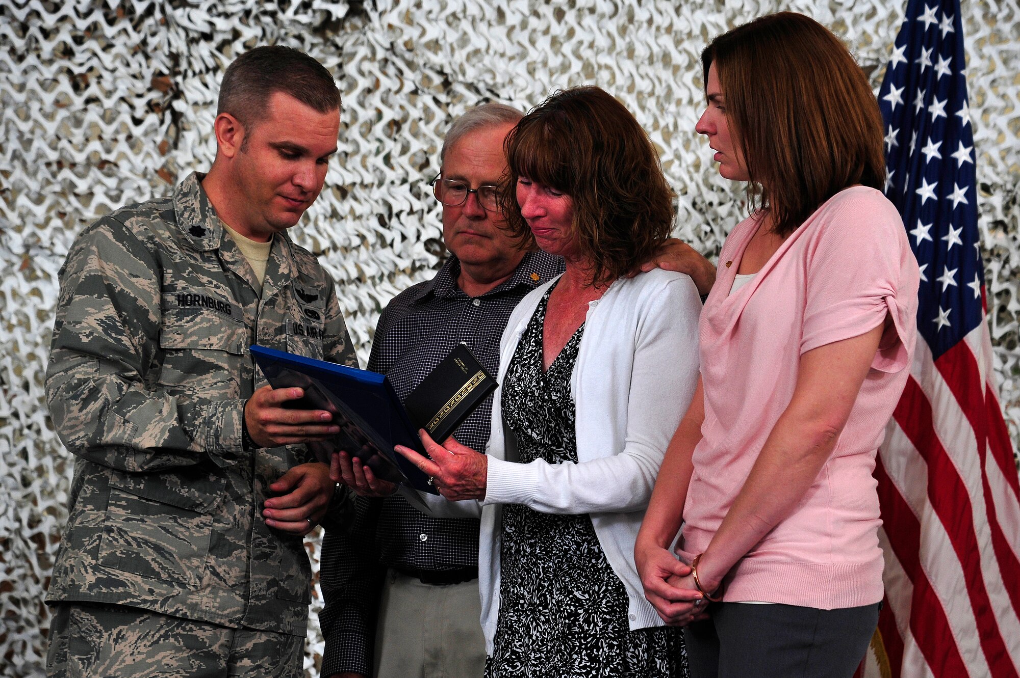 JOINT BASE MCGUIRE-DIX-LAKEHURST, N.J. -- Lt. Col. Christopher Hornburg, 819th Global Support Squadron commander, presents Staff Sgt. Shuan Fischer's father, Peter, mother, Debrorah, and sister, Katie, with the U.S. Air Force Commendation Medal in their son's name during his memorial service at the 621st Contingency Response Wing's Global Reach Deployment Center here Sept. 20, 2013. Fischer passed away in an off-base motorcycle accident Aug. 27. (U.S. Air Force photo by Tech. Sgt. Parker Gyokeres)