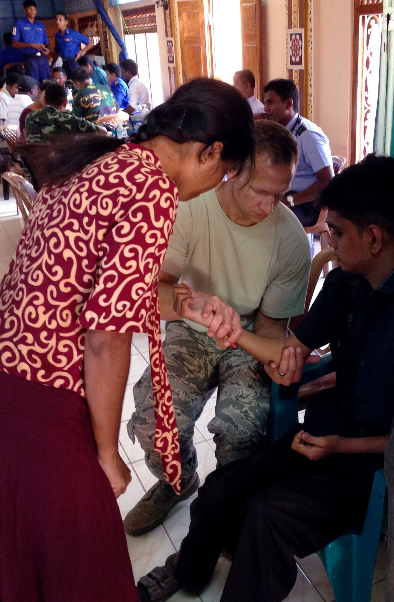 Air Force Maj. Eric Stephan examines a patient during the Pacific Angel Mission with the assistance of translator in the Jaffna Peninsula of Sri Lanka, July 28- Aug.18. (Photo courtesy of Tech. Sgt. Misty Ray, 142nd Fighter Wing Medical Group).