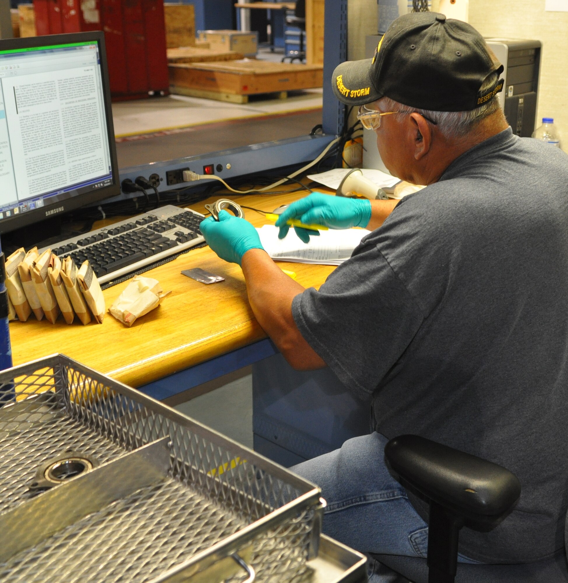 Bearing reconditioner Clem George of the 76th Commodities Maintenance Group compares a part number and serial number on an F108 gearbox bearing against the paperwork that accompanied the part. (Air Force photo by Mike Ray)