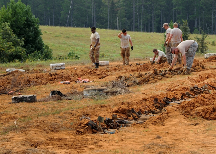 Airmen from the 2nd Civil Engineer Squadron Explosive Ordnance Disposal flight, place BDU-12s into man-made trenches at the main target circle at the Claiborne Bombing and Gunnery Range in Alexandria, La., Sept. 18, 2013. A BDU is a dummy bomb that pilots jettison during training. Within the BDU is a spotting cartridge that emits a phosphorous smoke cloud that accurately paints the target for pilots and range personnel. (U.S. Air Force photo/Senior Airman Joseph A. Pagán Jr.)