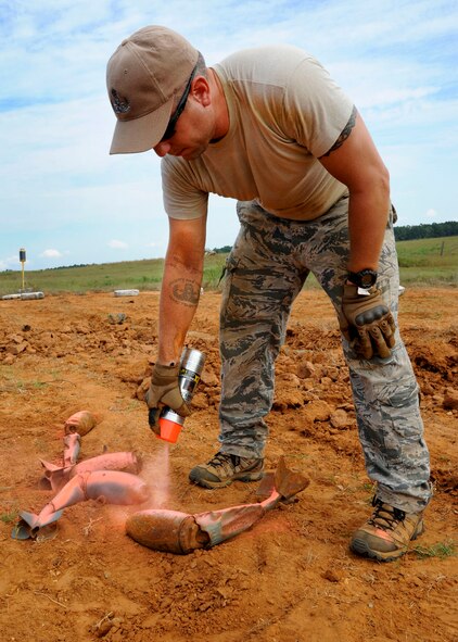 Staff Sgt. Joshua Flood, 2nd Civil Engineer Squadron Explosive Ordnance Disposal technician, paints a BDU-12 at the Claiborne Bombing and Gunnery Range in Alexandria, La., Sept. 18, 2013. A BDU is painted when after being identified as safe. A BDU contains a hazardous undetonated spotting cartridge which needs to be destroyed before being recycled as scrap metal. (U.S. Air Force photo/Senior Airman Joseph A. Pagán Jr.)