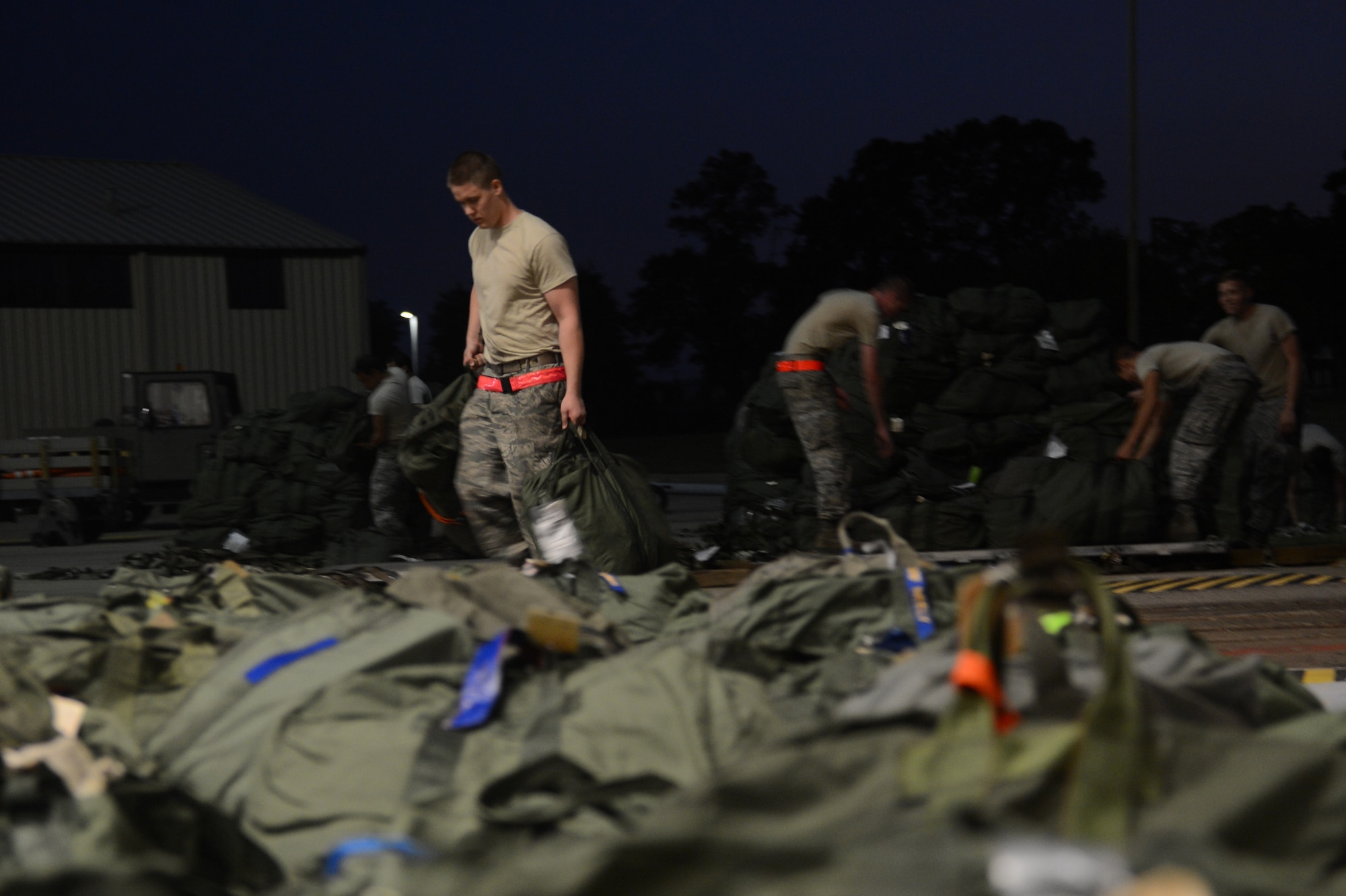 Members of 20th Fighter Wing  unload bags belonging to Airmen returning from a deployment at Shaw Air Force Base, S.C., Sept. 19, 2013. Approximately 400 Airmen from the2 0th Fighter Wing returned from South Korea. (U.S. Air Force photo by Airman 1st Class Krystal M. Jeffers/Released)