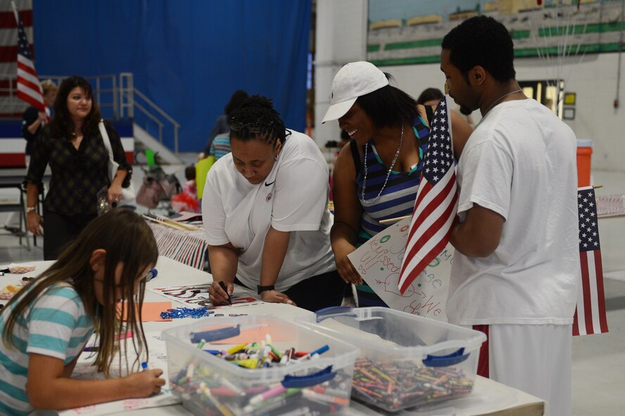 Families of 20th Fighter Wing Airmen make welcoming banners to greet their loved ones from a deployment at Shaw Air Force Base, S.C., Sept. 19, 2013. Approximately 400 Airmen returned from a five-month deployment to South Korea. (U.S. Air Force photo by Airman 1st Class Krystal M. Jeffers/Released)