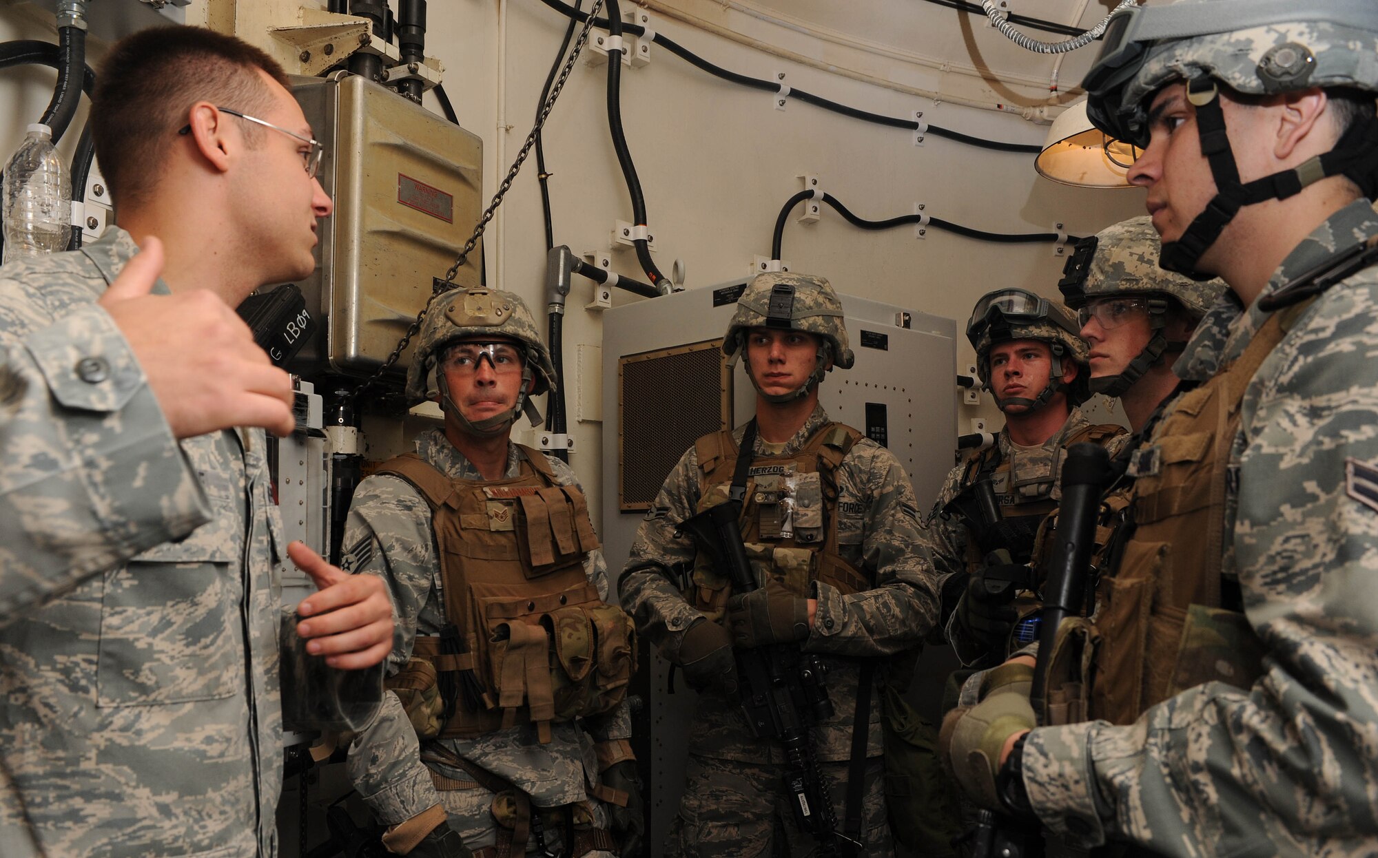 Senior Airman Joshua Knouff, 91st Missile Wing tactical response force member, briefs his group after an assault clearing procedure conducted at the U-01 training facility during a visit from Chief Master Sgt. Dave Nordel, Twentieth Air Force command chief at Minot Air Force Base, N.D., Sept. 16, 2013. Training of this kind helps to prepare Airmen to respond in the event of an attack on a launch facility in the missile field.(U.S. Air Force photo/Senior Airman Stephanie Sauberan)