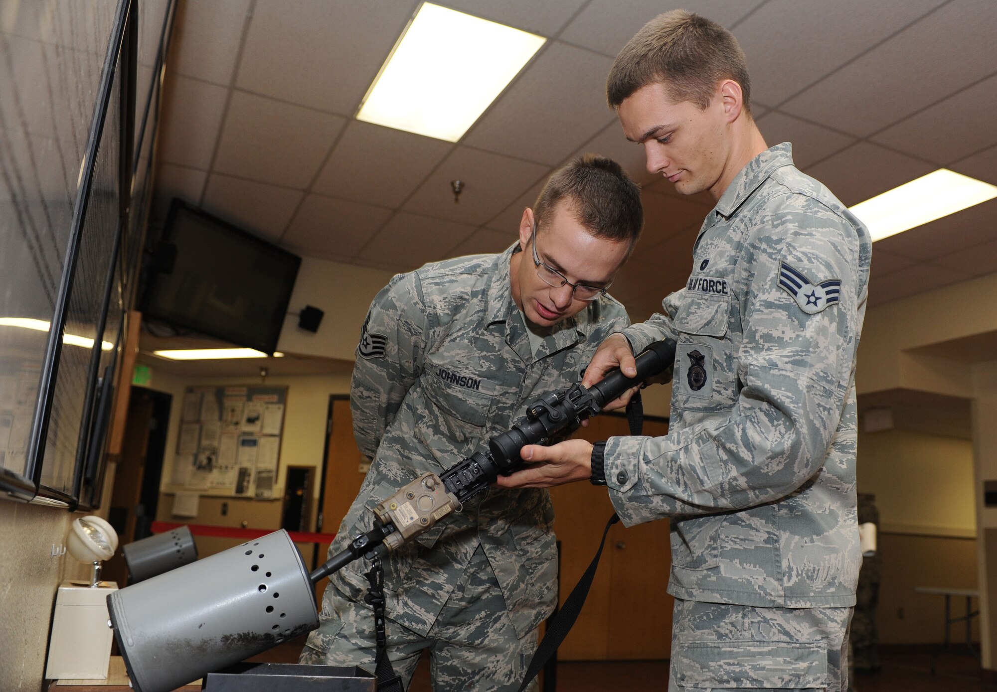 Staff Sgt. Dylan Johnson, 5th Security Forces Squadron assistant armory non-commissioned officer in charge, observes weapon clearing techniques performed Senior Airman Preston Petersen, 5th SFS armorer during a visit from Chief Master Sgt. Dave Nordel, Twentieth Air Force command chief at Minot Air Force Base, N.D., Sept. 16, 2013. Safety is paramount during any situation involving weapons systems and proper checks are performed at each stage of their issue to negate the possibility of injury. (U.S. Air Force photo/Senior Airman Stephanie Sauberan)