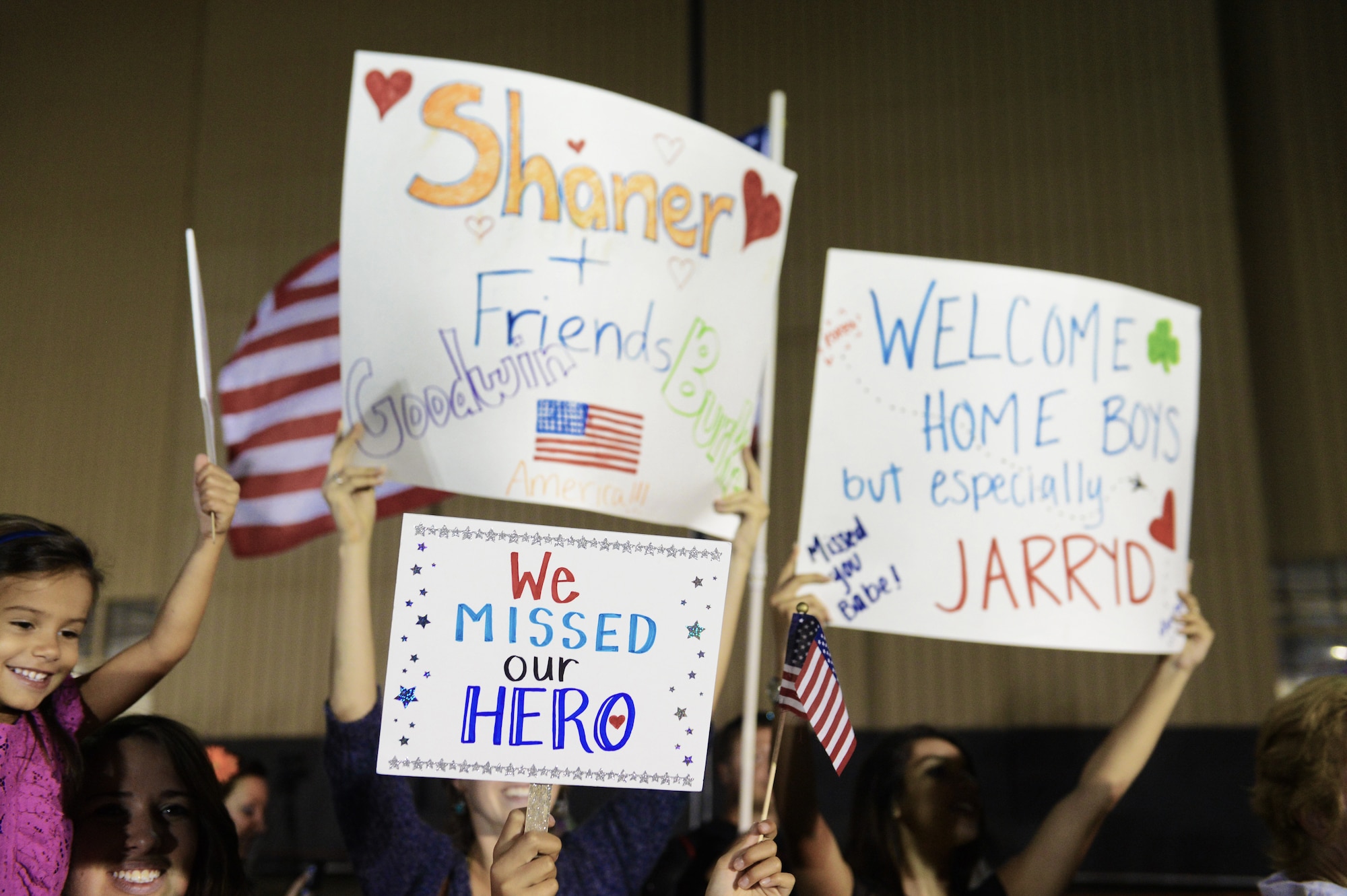 Families, friends and co-workers wait with signs as Airmen return home, Shaw Air Force Base, S.C., Sept. 19, 2013. Airmen from the 20th Fighter Wing were deployed to Osan AB, Republic of Korea, for five months in an effort to bolster regional security in the region. (U.S. Air Force photo by Senior Airman Tabatha Zarrella/Released)