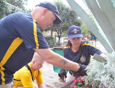 (From left) Master Chief Petty Officer Rodney Ruth, Chief Petty Officer-select John Ross and Master Chief Petty Officer Tonya Carlson plant flowers during a volunteer project to help beautify downtown San Antonio. (Photo by Larry Coffey, Navy Medical Education and Training Command Public Affairs)