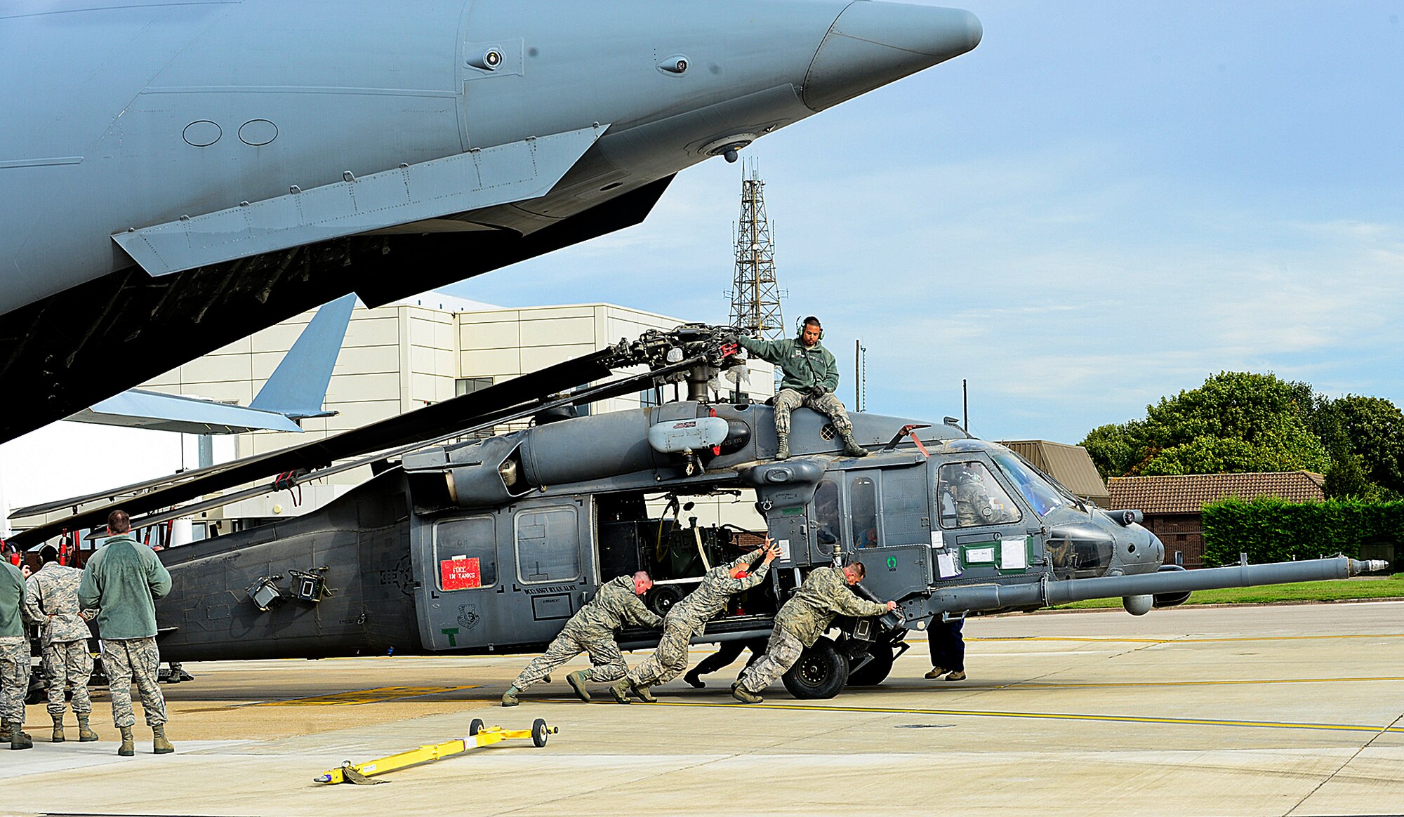 Airmen from the 748th Aircraft Maintenance Squadron offload one of the two HH-60G Pave Hawk helicopters from a C-17 Globemaster III at Royal Air Force Mildenhall Sept. 19, 2013. Nearly 100 Airmen from the 56th Rescue Squadron and 748th AMXS, stationed at nearby RAF Lakenheath, returned from Bagram Airfield, Afghanistan, following an almost four month deployment. (U.S. Air Force photo by Airman 1st Class Dana J. Butler/Released)