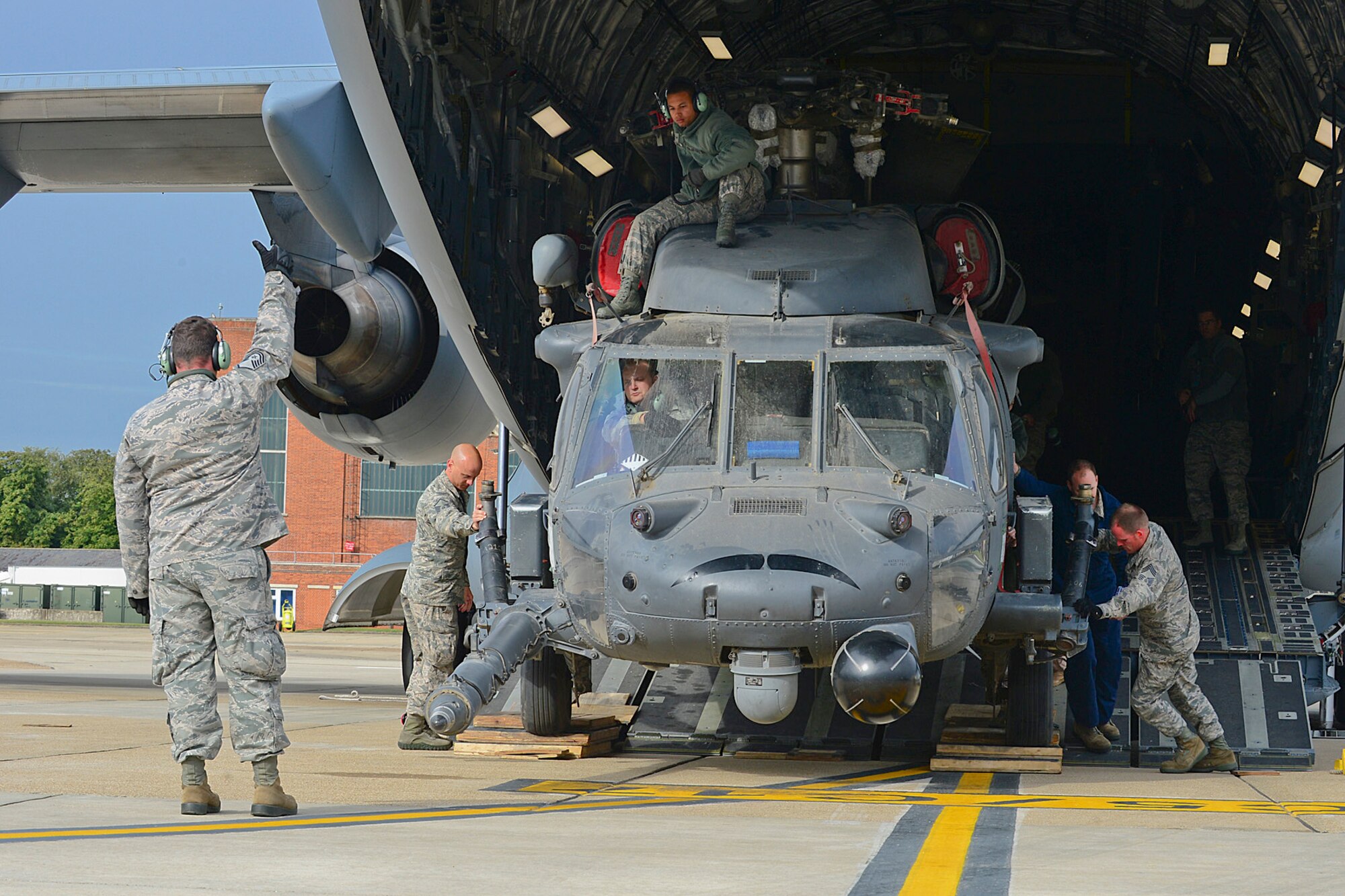 Airmen from the 748th Aircraft Maintenance Squadron offload one of the two HH-60G Pave Hawk helicopters from a C-17 Globemaster III at Royal Air Force Mildenhall Sept. 19, 2013. Nearly 100 Airmen from the 56th Rescue Squadron and 748th AMXS, stationed at RAF Lakenheath, returned from Bagram Airfield, Afghanistan, following an almost four month deployment. (U.S. Air Force photo by Airman 1st Class Dana J. Butler/Released)