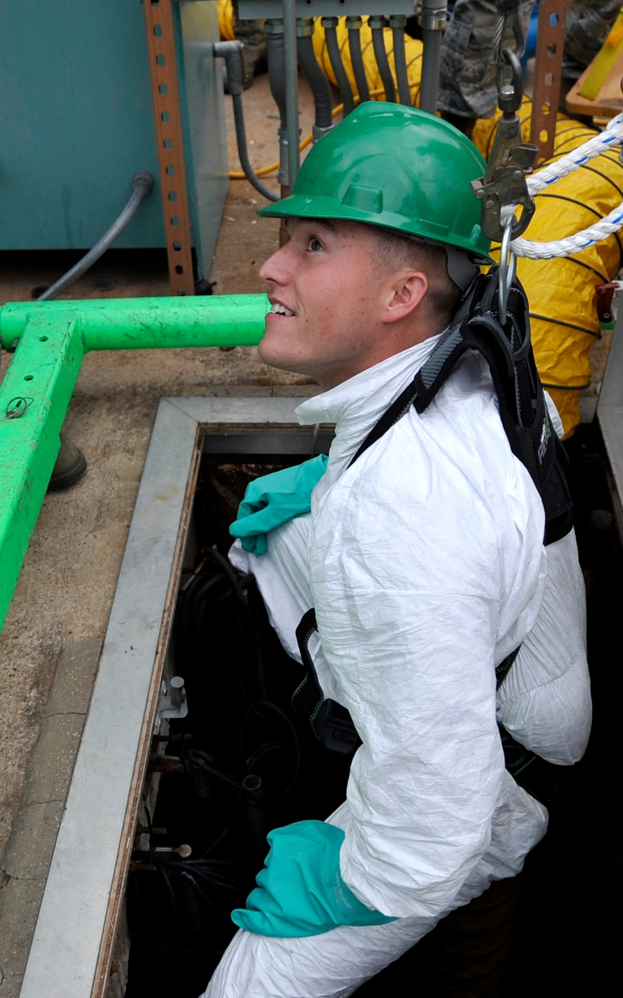 Airman 1st Class Jefferson Bowler, 2nd Civil Engineer Squadron water and fuel system maintenance apprentice, is lowered underground to install a bypass system so that base plumbing will function normally during maintenance on Barksdale Air Force Base, Sept. 17, 2013. Bowler wore a harness for safety and fresh air is also pumped underground toward Bowler to help keep air breathable while performing maintenance. (U.S. Air Force photo/Airman 1st Class Benjamin Raughton)