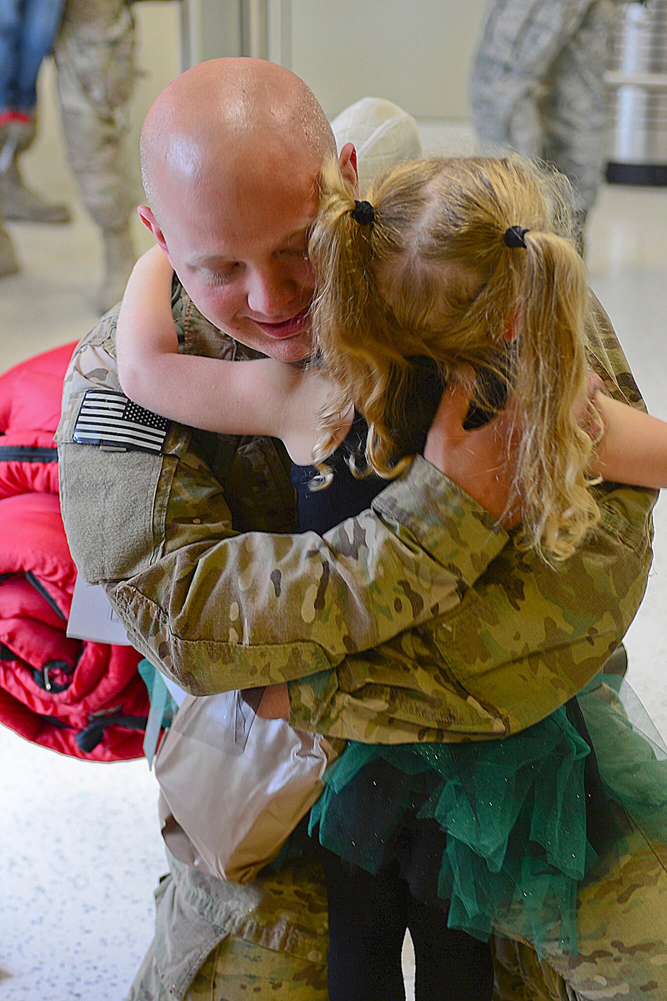 Senior Airman Mark Delaney, 748th Aircraft Maintenance Squadron, hugs his daughter Lexi, 4, at Royal Air Force Mildenhall Sept. 19, 2013, following an almost four month deployment to Bagram Airfield, Afghanistan. Nearly 100 Airmen from the 56th Rescue Squadron and 748th AMXS, stationed at RAF Lakenheath, returned this week. (U.S. Air Force photo by Airman 1st Class Dana J. Butler/Released)