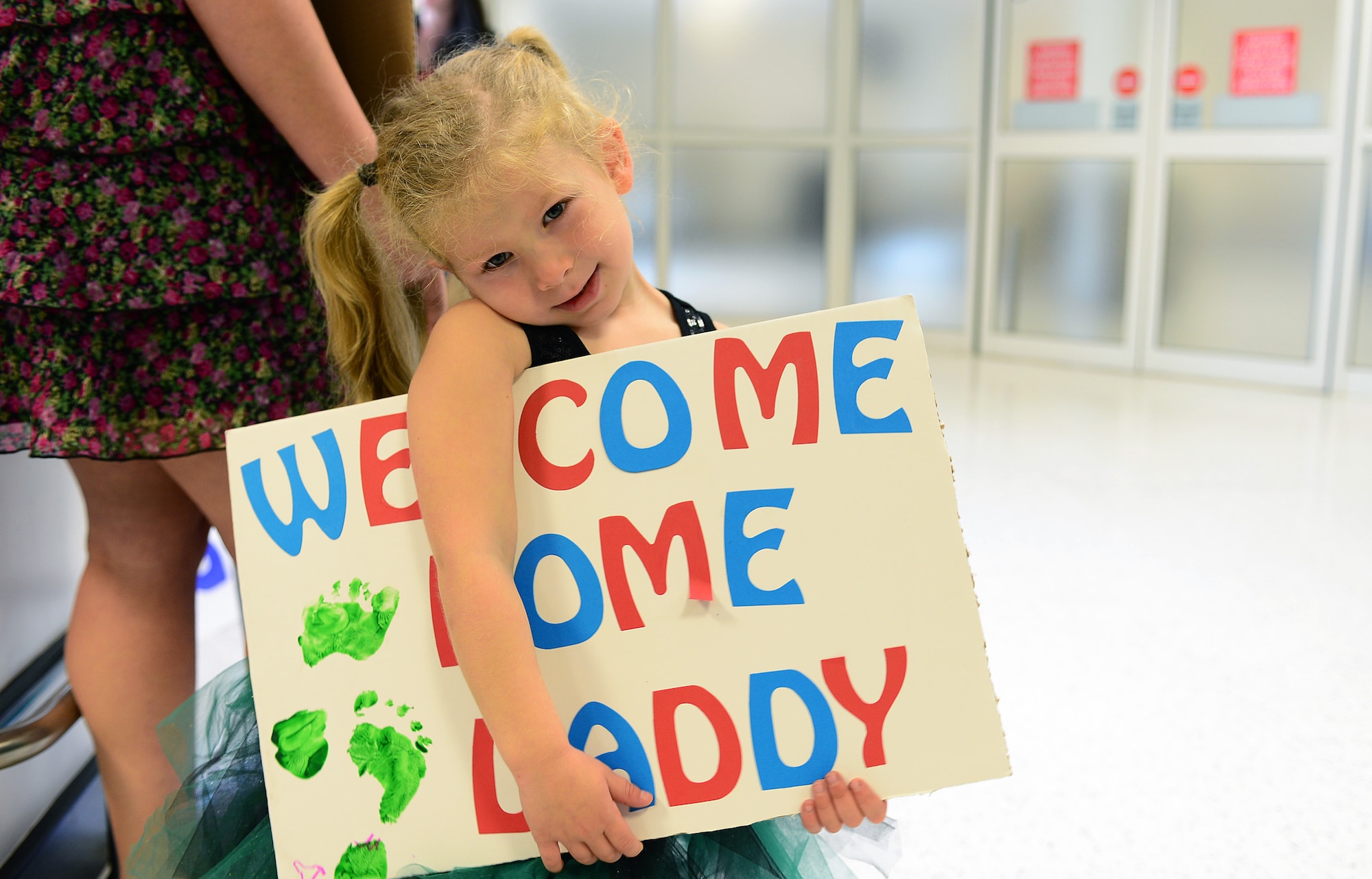 Lexi, 4-year-old daughter of Senior Airman Mark Delaney, 748th Aircraft Maintenance Squadron, waits for her father at Royal Air Force Mildenhall Sept. 19, 2013, following his four month deployment to Bagram Airfield, Afghanistan. Nearly 100 Airmen from the 56th Rescue Squadron and 748th AMXS, stationed at RAF Lakenheath, returned this week. (U.S. Air Force photo by Airman 1st Class Dana J. Butler/Released)