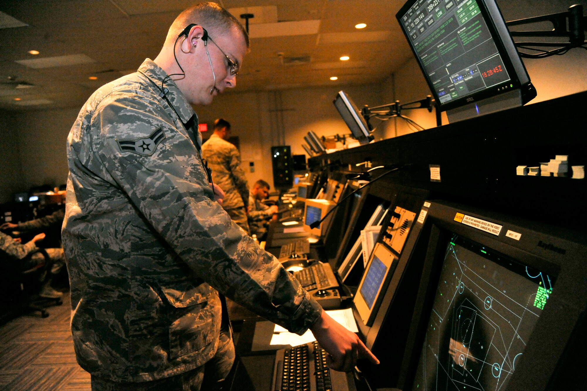 U.S. Air Force Airman 1st Class Derek Barb, 509th Operation Support Squadron air traffic control apprentice, gives a “point out” to the arrival controller at Whiteman Air Force Base, Mo., Sept. 9, 2013. Point outs are used to alert the incoming controller of any aircraft within the airspace. (U.S. Air Force photo by Airman 1st Class Keenan Berry/Released)
