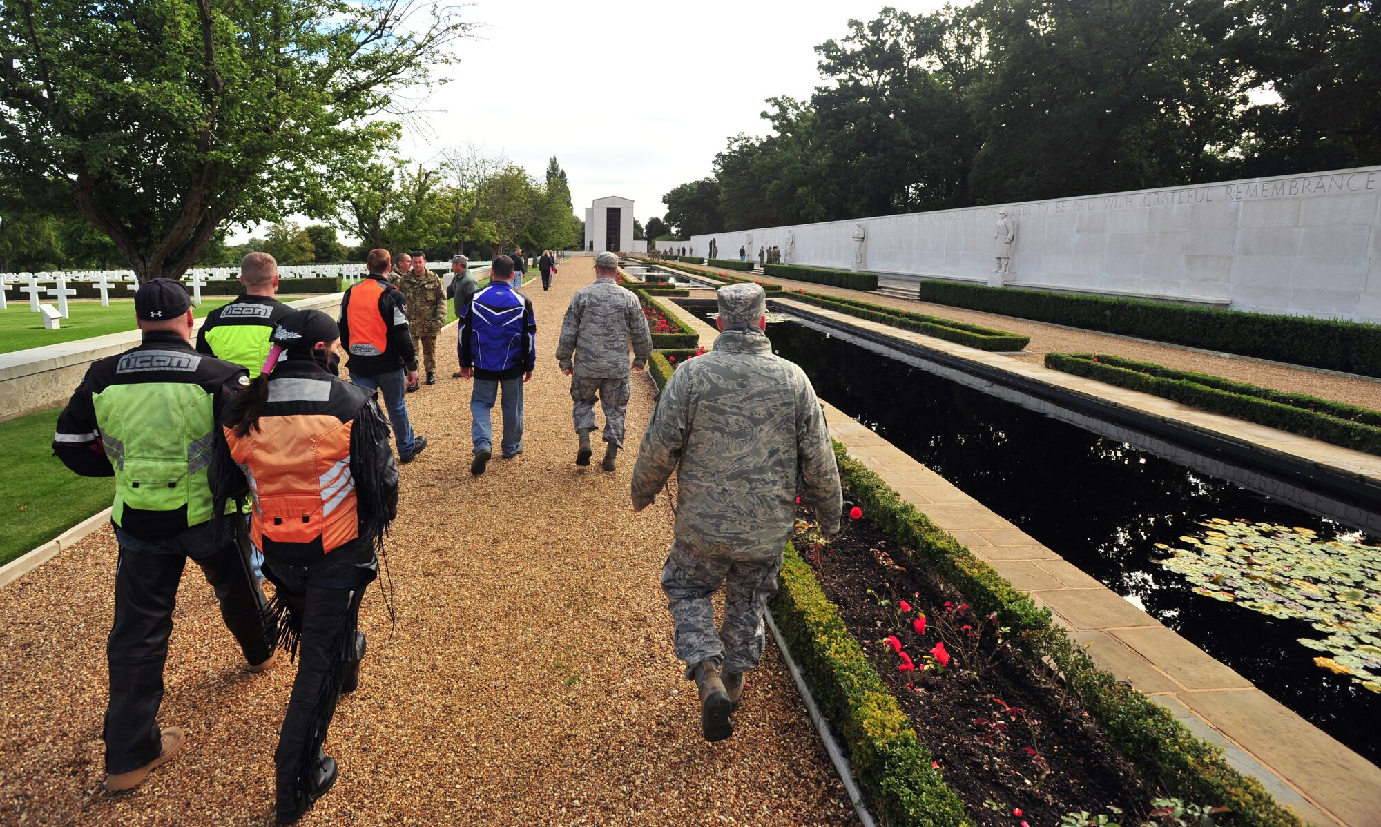 Participants of the joint RAF Mildenhall and RAF Lakenheath Rolling Thunder motorcycle rally walk The Great Mall Sept. 19, 2013, in the Madingley American Cemetery near Cambridge, England. The Great Mall contains 5,126 persons missing in action or who lost their lives without positive identification.  One name of the 5,126 is lettered in gold, highlighting that person received the Medal of Honor. (U.S. Air Force photo by Senior Airman Christine Griffiths)