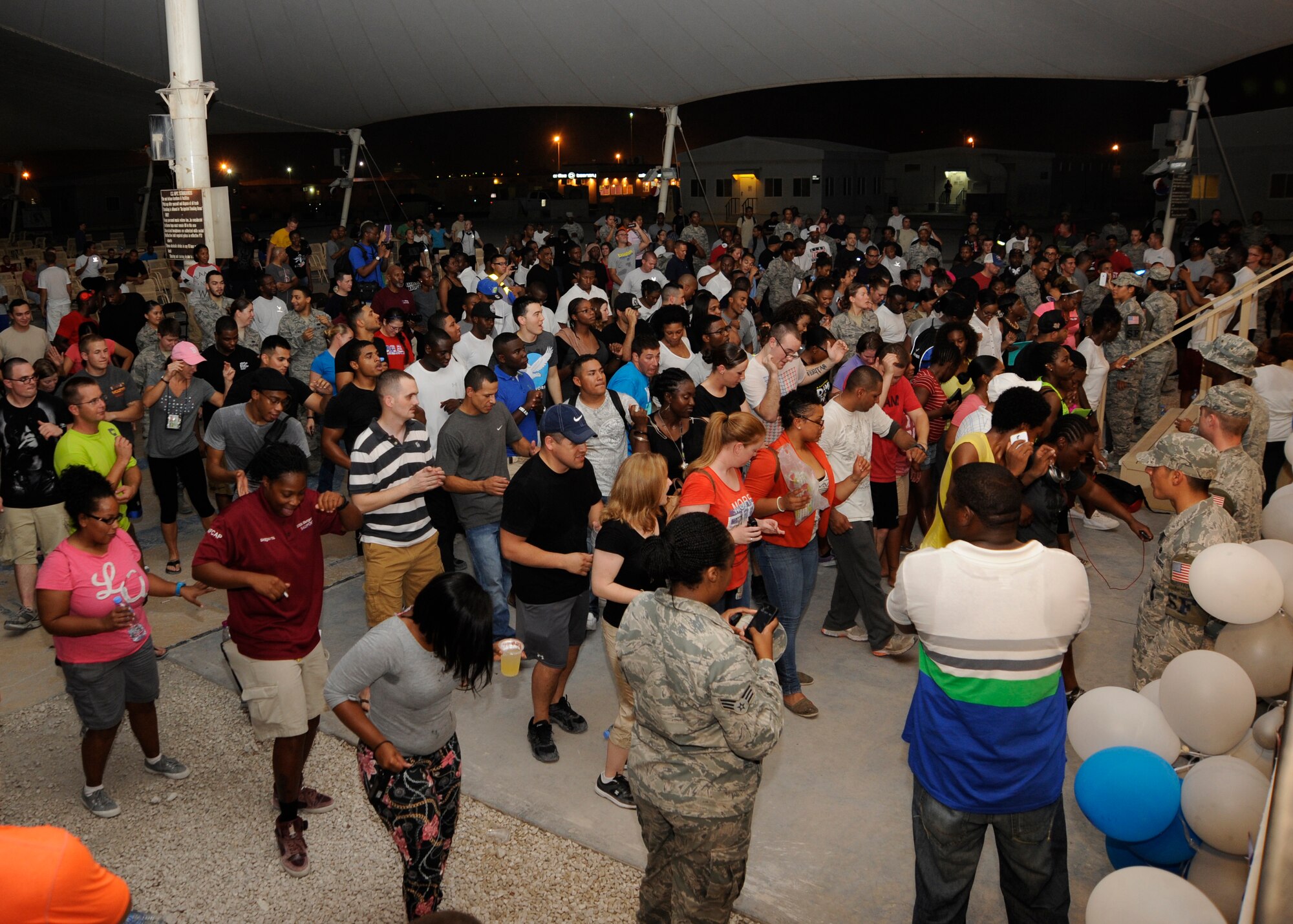 A Grand Slam audience does the “Cupid Shuffle” during the Air Force birthday celebration at the 379th Air Expeditionary Wing in Southwest Asia, Sept. 18, 2013. The 379th Expeditionary Force Support Squadron treated deployed troops to a night of entertainment for the service’s 66th year. (U.S. Air Force photo/Senior Airman Bahja J. Jones) 