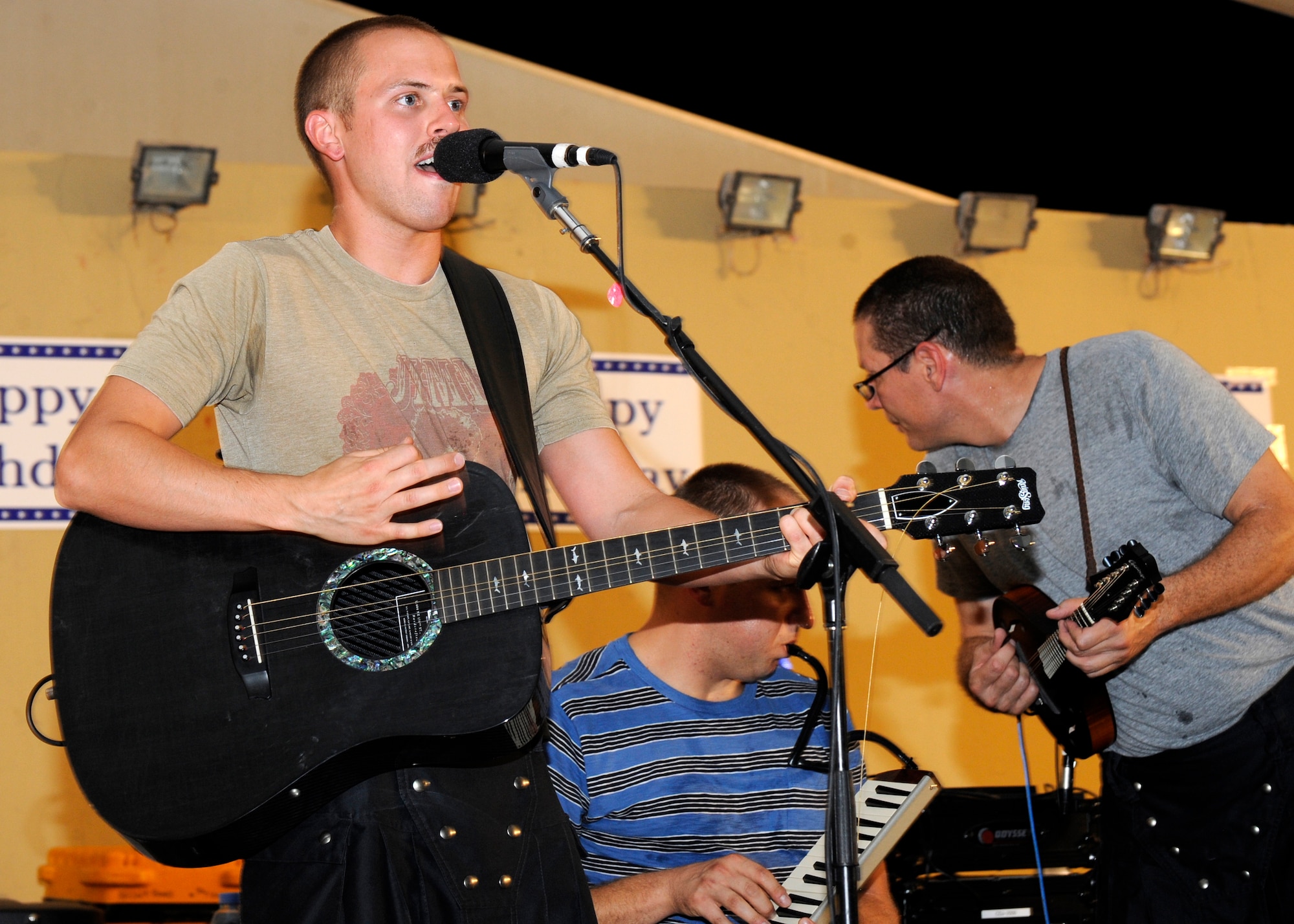 Airman 1st Class Ben Johnson sings “Hey Ya,” during a U.S. Air Forces Central Command band performance at the 379th Air Expeditionary Wing in Southwest Asia, Sept. 18, 2013. The folk band put on a performance of folk, Reggae, and popular hits before singing “Happy Birthday” and the “Air Force Song” for the service’s 66th year. Johnson is an AFCENT band percussionist, guitarist and vocalist deployed from Travis Air Force Base, Calif. (U.S. Air Force photo/Senior Airman Bahja J. Jones) 