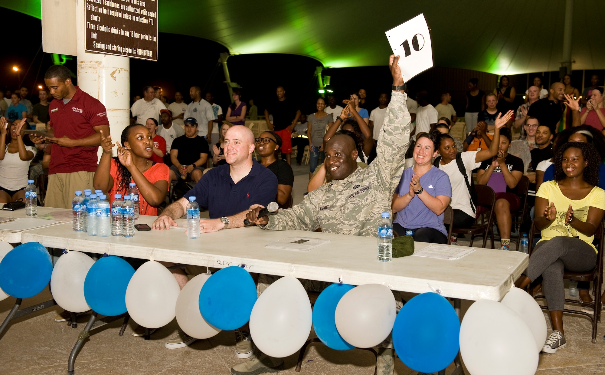 Chief Master Sgt. Rory Wicks gives a '10' rating to the competition winners during the "You Got Served" dance competition at the 379th Air Expeditionary Wing in Southwest Asia, Sept. 18, 2013. The event pinned the wing's most talented dancers in a cut-throat show of skills and determination with Senior Airman Stephan Hall and Staff Sgt. Ephraim Colburn winning the crown in the end. Wicks is the 379th AEW command chief and a Kinston, N.C., native. Hall is a 379th Expeditionary Force Support Squadron services journeyman deployed from Wright-Patterson Air Force Base, Ohio, and a Dayton, Ohio, native. Colburn is a 379th Expeditionary Logistics Readiness Squadron issue 10 supervisor deployed from Royal Air Force Mildenhall, U.K., and hails from Philadelphia. (U.S. Air Force photo/Staff Sgt. Benjamin W. Stratton)