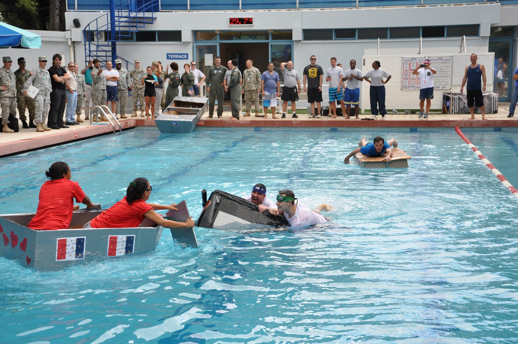 Men and women from the 425th Air Base Squadron and NATO celebrate the United States Air Force’s 66th birthday with a cardboard boat regatta at the NATO pool at Izmir, Turkey, Sept. 18, 2013. (U.S. Air Force photo by Tanju Varlikli/Released)