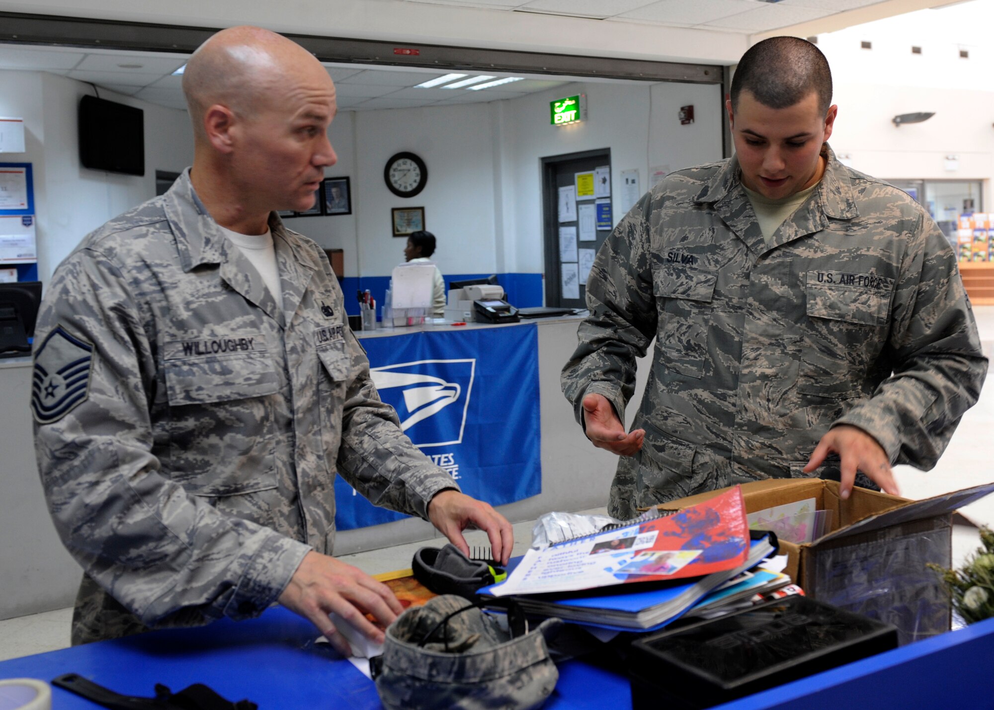 Master Sgt. Nick Willoughby has his parcel inspected by Senior Airman Christopher Silva at the 379th Air Expeditionary Wing in Southwest Asia. All outgoing packages must be inspected prior to shipment. Willoughby is the U.S. Air Forces Central Command petroleum, fuels and lubricants manager deployed from Fort Belvoir, Va., and a Knoxville, Tenn., native. Silva is a 379th Expeditionary Communications Squadron postal clerk deployed from Ramstein Air Base, Germany, and hails from Kearny, N.J. (U.S. Air Force photo/Senior Airman Bahja J. Jones) 

