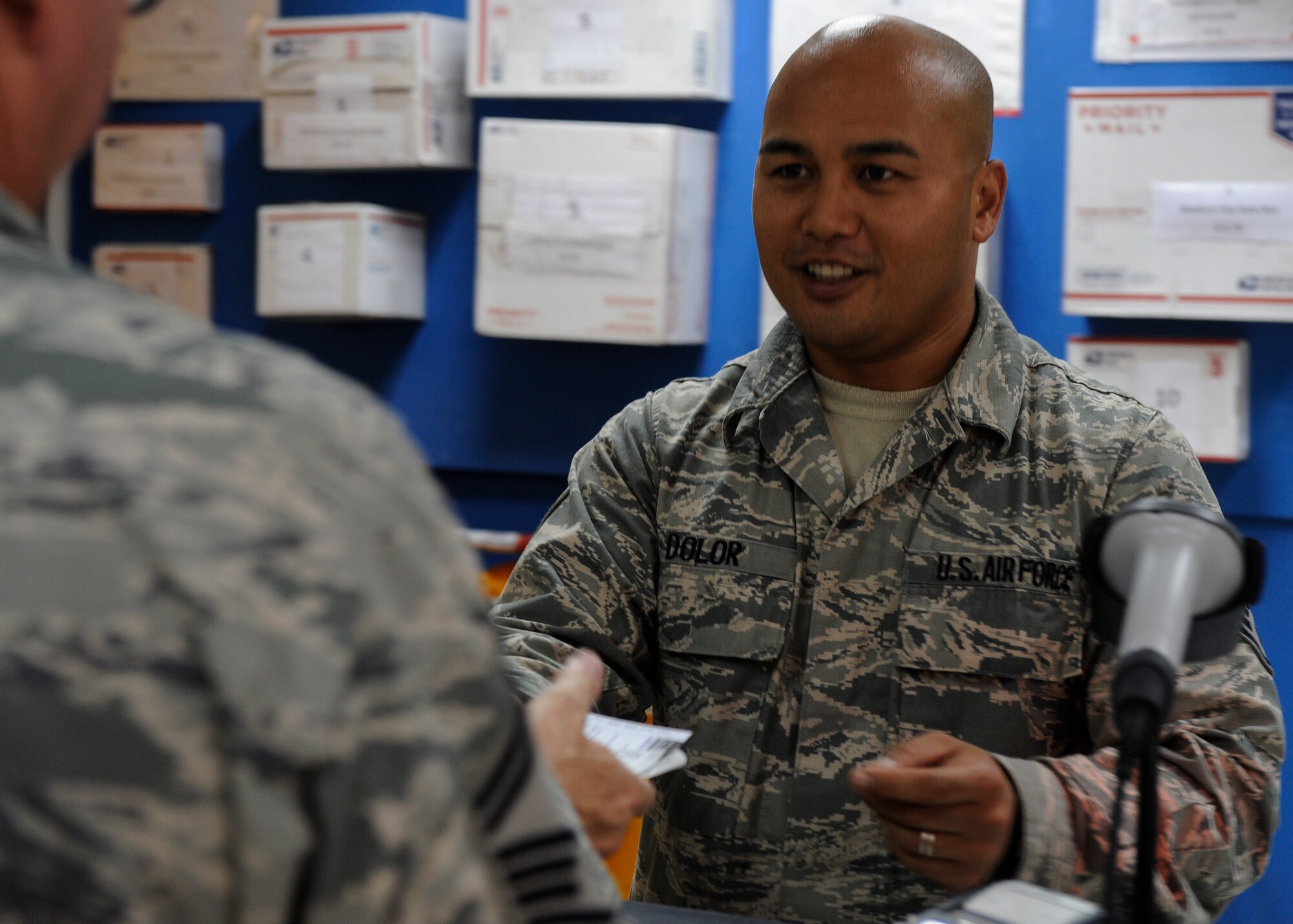 Staff Sgt. Eugene Dolor helps a customer mail a package at the 379th Air Expeditionary Wing in Southwest Asia, Sept. 17, 2013. The 379th AEW is the only location in the U.S. Air Forces Central Command area of responsibility with two post offices open seven days a week. Dolor is a 379th Expeditionary Communications Squadron postal specialist deployed from Ramstein Air Base, Germany, and a Virginia Beach, Va., native. (U.S. Air Force photo/Senior Airman Bahja J. Jones) 

