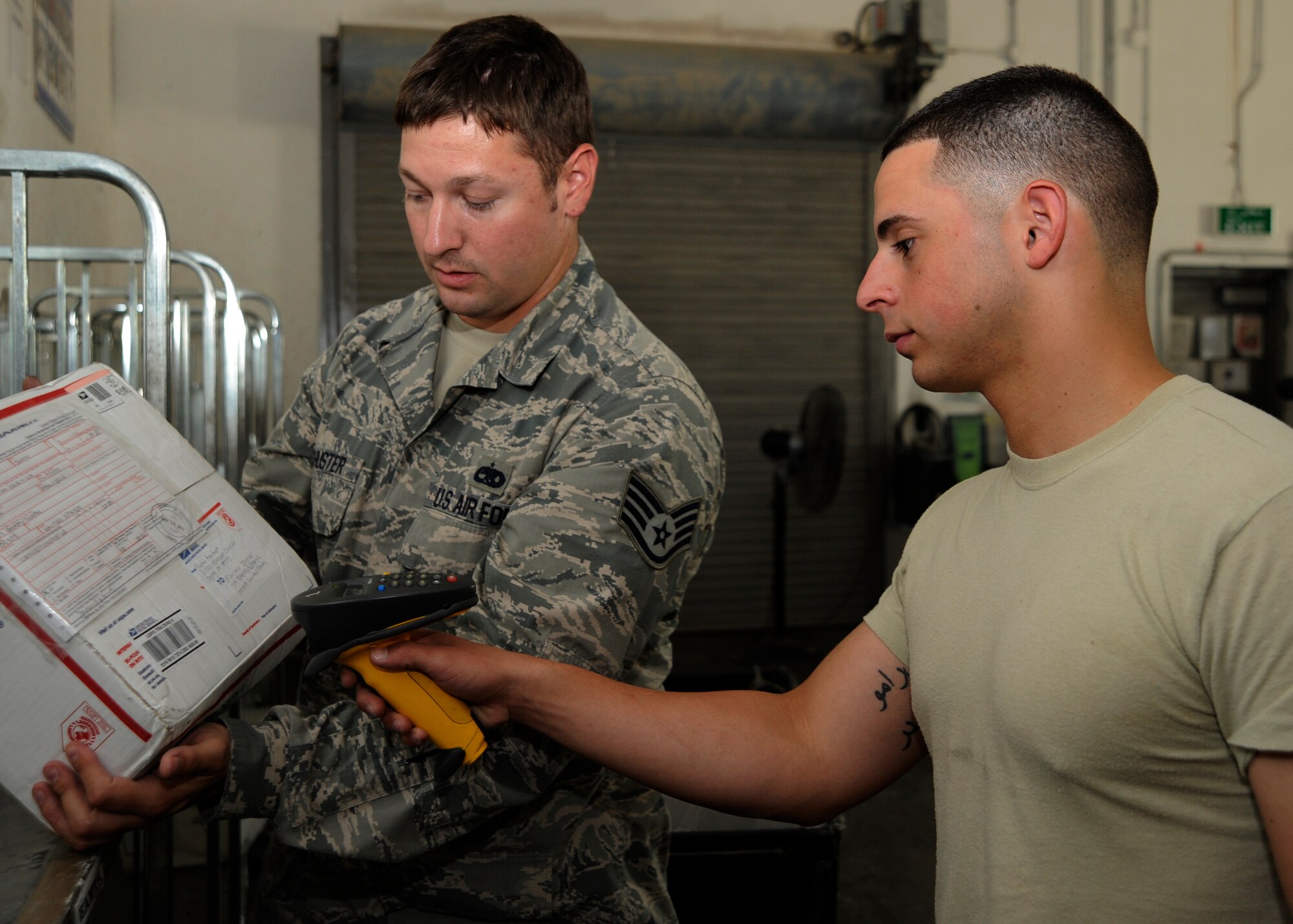 Staff Sgt. Bradley Schuster and Airman 1st Class Ramon Torres Vazquez scan packages into their tracking system at the 379th Air Expeditionary Wing in Southwest Asia, Sept. 17, 2013. Schuster is a 379th Expeditionary Maintenance Squadron tactical aircraft maintainer and unit mail clerk deployed from Nellis Air Force Base, Nev., and hails from Madison, Wis. Torres Vazquez is a 379th Expeditionary Communications Squadron postal clerk deployed from Ramstein Air Base, Germany, and a Ponce, Puerto Rico, native. (U.S. Air Force photo/Senior Airman Bahja J. Jones) 

