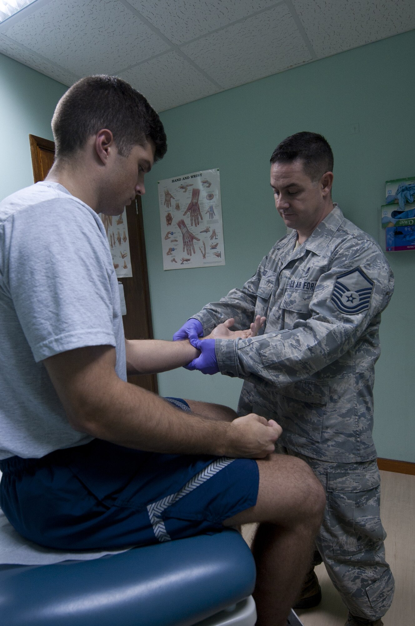 U.S. Air Force Master Sgt. Claude Russo, 380th Air Expeditionary Wing independent duty medical technician, checks for wrist function on a patient who just injured himself lifting at an undisclosed location in Southwest Asia Sept. 17, 2013. Russo, as an IDMT, can formally diagnose what is wrong with the patient and provide care on the spot to correct the issue. Russo calls Oklahoma City, Okla., home and is deployed from Joint Base Elmendorf-Richardson, Alaska. (U.S. Air Force photo by Staff Sgt. Jacob Morgan)