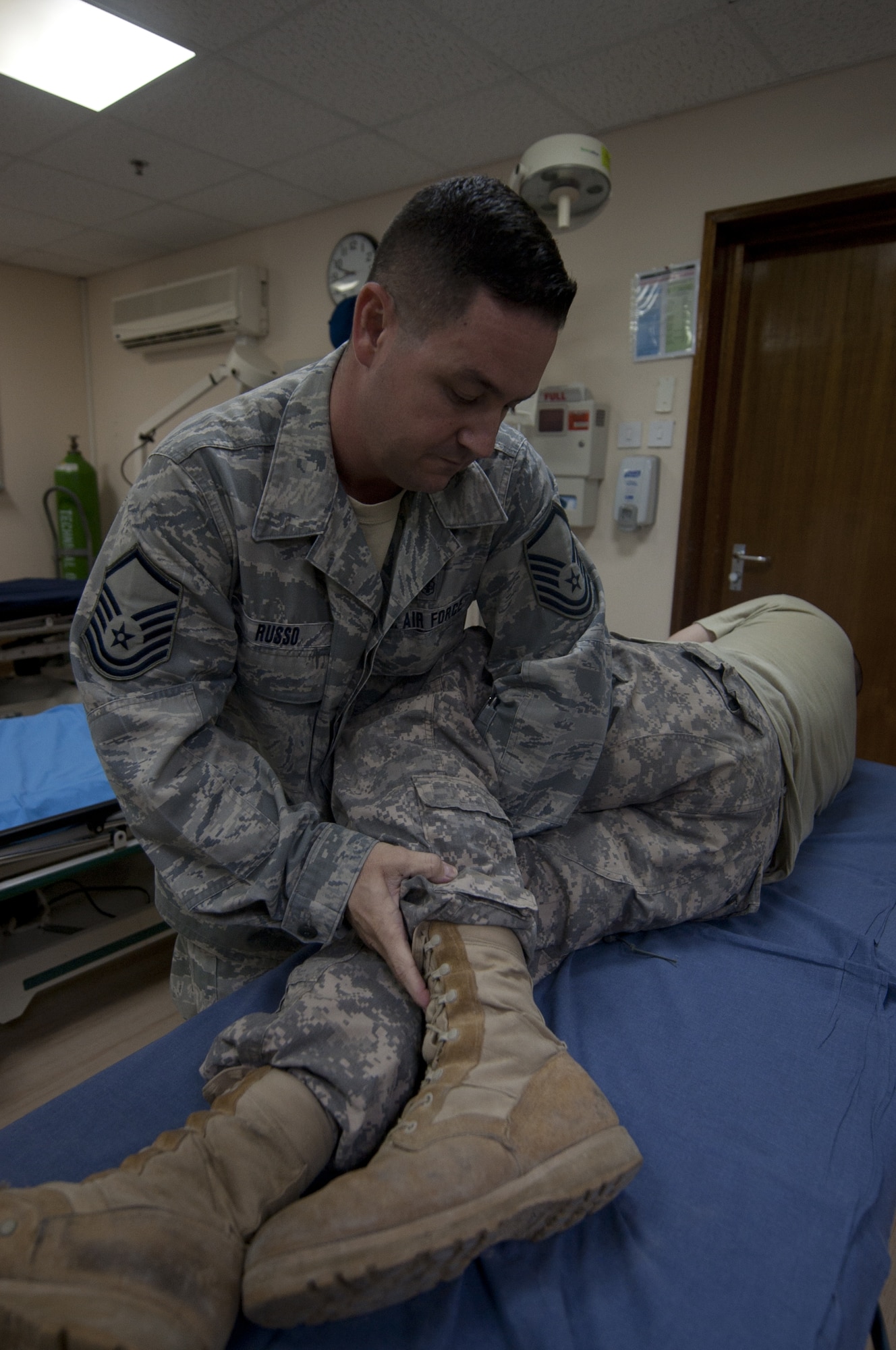 U.S. Air Force Master Sgt. Claude Russo, 380th Air Expeditionary Wing independent duty medical technician, straightens the hips of a patient who was having back problems at an undisclosed location in Southwest Asia Sept. 17, 2013. Russo, as an IDMT, can formally diagnose what is wrong with the patient and provide care on the spot to correct the issue. Russo calls Oklahoma City, Okla., home and is deployed from Joint Base Elmendorf-Richardson, Alaska. (U.S. Air Force photo by Staff Sgt. Jacob Morgan)