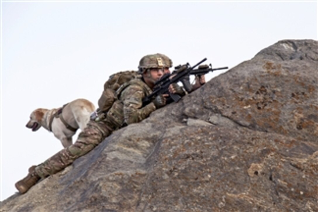 U.S. Army Staff Sgt. Sean Pabey left, Sgt. James Carlberg, right, and his dog Staff Sgt. Abby provide over watch from the mountaintops of Maiden Shar, Afghanistan, during operation Apache Shield on Sept. 1, 2013.  The operation allows U.S soldiers to assist the Afghan Military Police by showing a larger presence on the surrounding mountaintops to deter any enemies of Afghanistan in the area from launching indirect fire onto Forward Operating Base Airborne.   