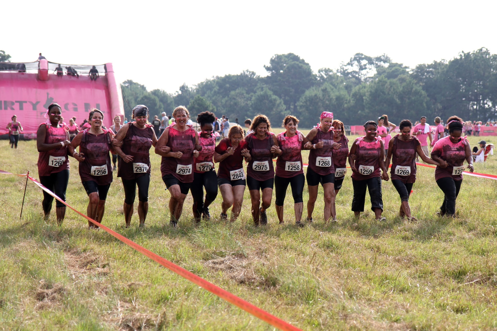Senior Master Sgt. Karla Rose, 315th Force Support Squadron superintendent, gives Master Sgt. Barbara Sosebee, 315th Mission Support Group career advisor, some support Saturday Sept. 14, 2013, as she finishes traversing a cargo net during the Dirty Girl Mud Run held at Legare Farms on Johns Island, S.C. The women’s-only 5K run helps raise money for breast and ovarian cancer research while also increasing awareness of the warning signs and symptoms of these diseases.