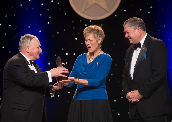 Former Secretary of the Air Force Michael Donley (right) looks on as his wife Gail (center) shows her surprise after the Air Force Association's Chairman of the Board George Muellner (left) announced the new Mike and Gail Donley Special Scholarship Program during the United States Air Force Anniversary Dinner Sept. 18, 2013, at the National Harbor, Washington, D.C. The dinner celebrated the 66th Anniversary of the Air Force during the Air Force Association's 2013 Air & Space Conference and Technology Exposition. AFA sponsors the annual conference to promote professional development in support of the total Air Force. (U.S. Air Force photo/Jim Varhegyi)
