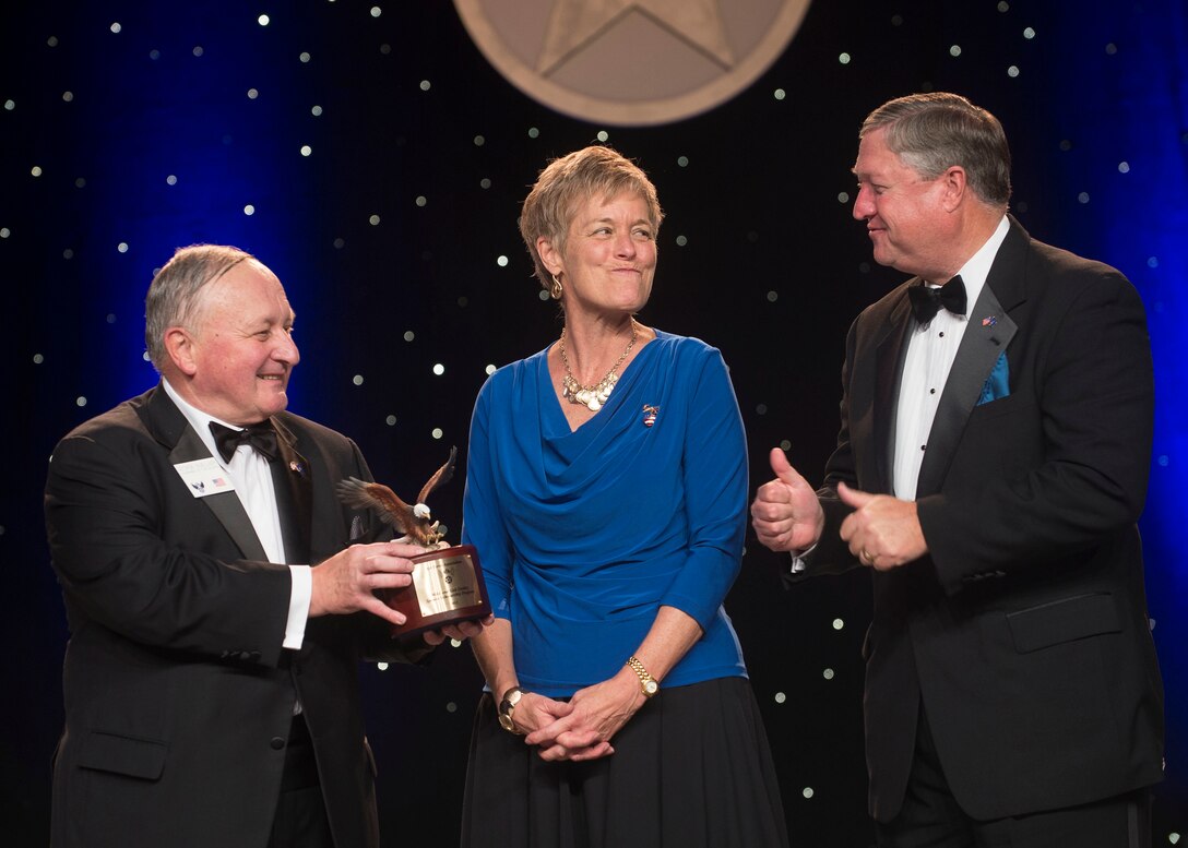 Former Secretary of the Air Force Michael Donley (right) looks on as his wife Gail (center) shows her surprise after the Air Force Association's Chairman of the Board George Muellner (left) announced the new Mike and Gail Donley Special Scholarship Program during the United States Air Force Anniversary Dinner Sept. 18, 2013, at the National Harbor, Washington, D.C. The dinner celebrated the 66th Anniversary of the Air Force during the Air Force Association's 2013 Air & Space Conference and Technology Exposition. AFA sponsors the annual conference to promote professional development in support of the total Air Force. (U.S. Air Force photo/Jim Varhegyi)