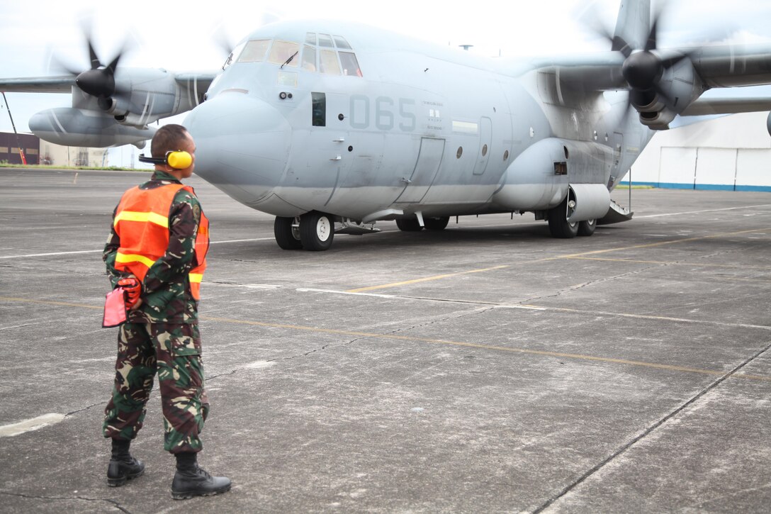 Philippine Air Force Tech. Sgt. Seno Nellas waits as a KC-130 Hercules aircraft arrives Sept. 14 carrying Marines for Amphibious Landing Exercise 2014 at Clark Air Field, Pampanga, Republic of the Philippines. Nellas is the noncommissioned officer in charge of base operations with the 600th Air Base Wing, part of the Philippine Air Force. The arriving Marines are with the 13th Marine Expeditionary Unit, the 3d Marine Expeditionary Brigade and III Marine Expeditionary Force.