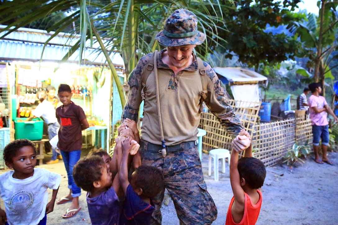 A U.S. Marine with Battalion Landing Team 1/4, 13th Marine Expeditionary Unit, plays with children from the local town during Amphibious Landing Exercise 2014 at Crow Valley, Philippines, Sept. 17, 2013. PHIBLEX is a bilateral training exercise designed to demonstrate the United States and Republic of the Philippines commitment to mutual security and strengthen our long-term partnership, while ensuring the readiness of a bilateral force able to rapidly respond to regional humanitarian crises. 